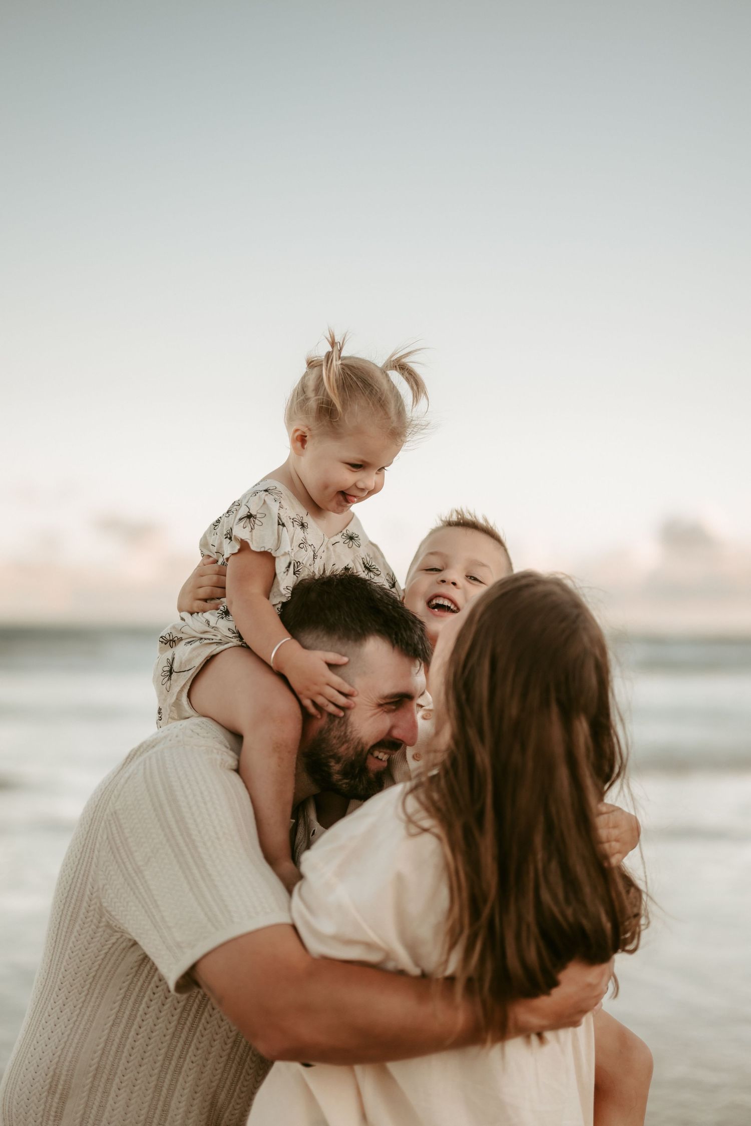 Intimate family embrace captured during sunset at the beach.