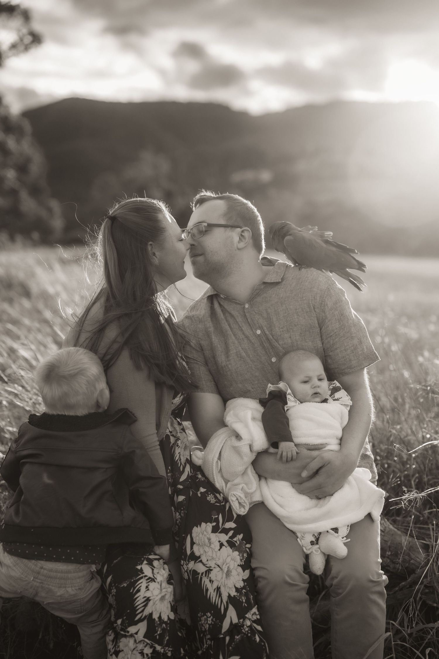 An intimate black and white portrait session in a sunlit field.