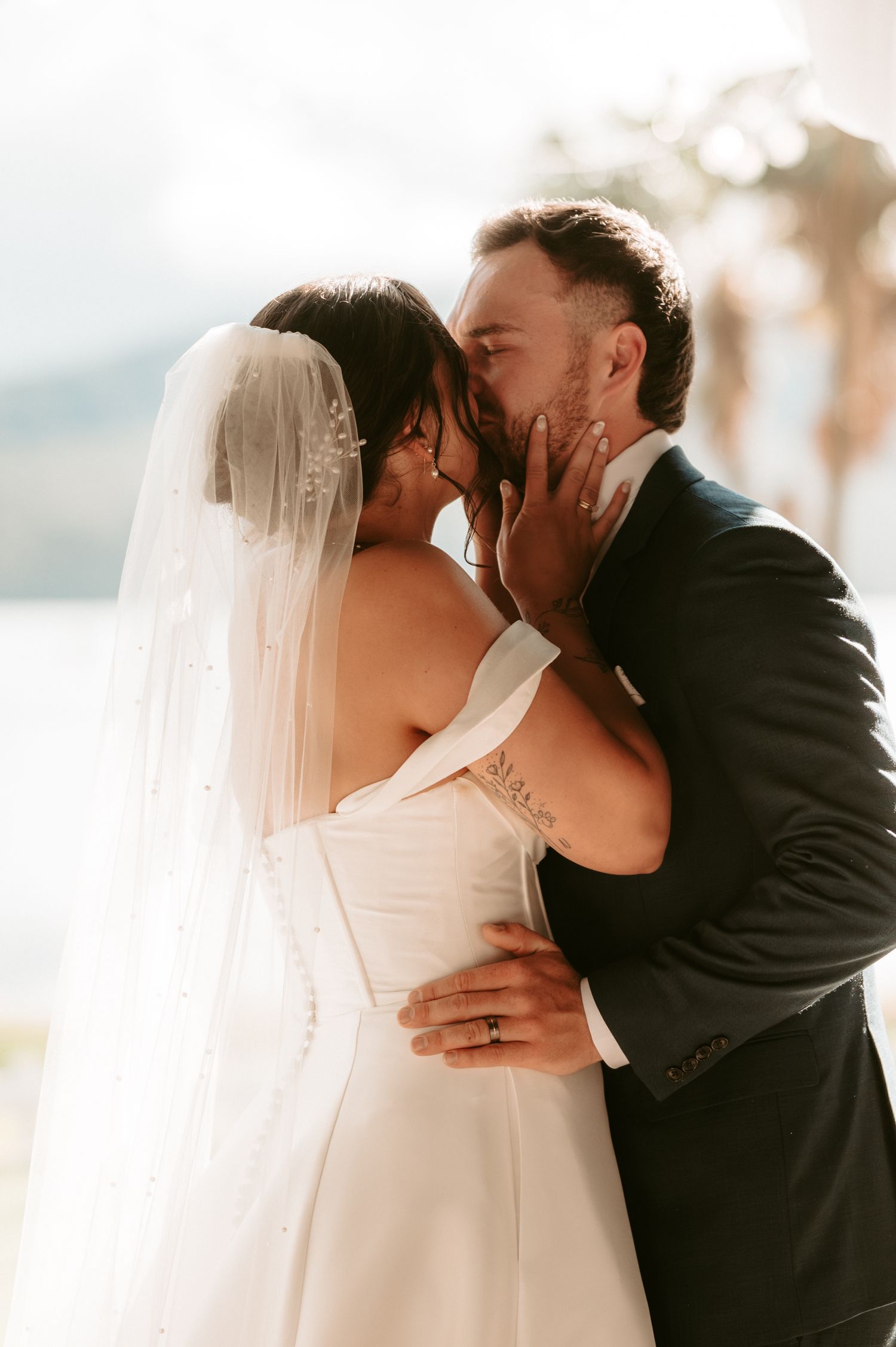 Romantic wedding kiss sequence captured in warm sunset lighting.
