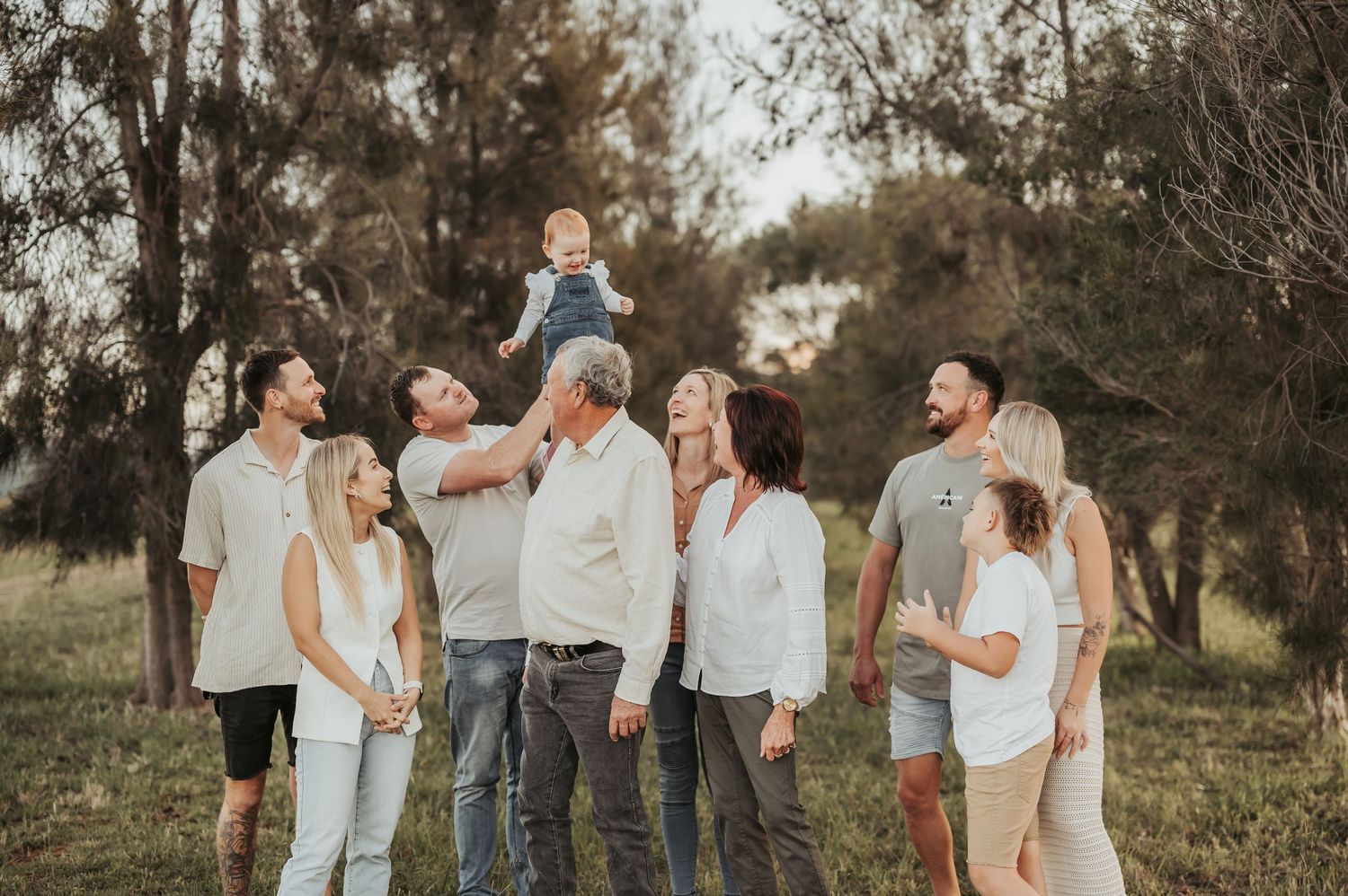A group photo of family members in coordinated outfits standing in a park.