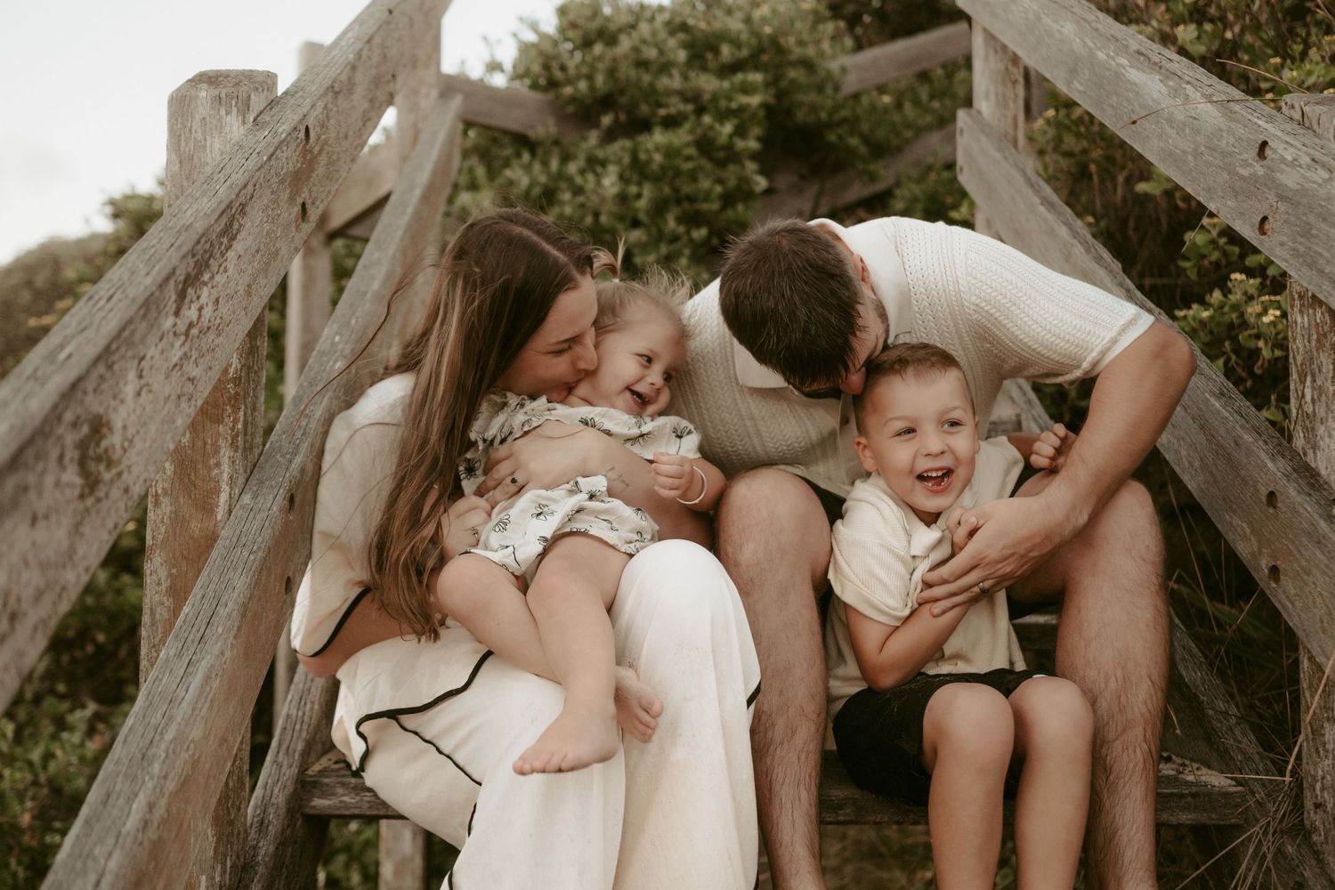 Candid moments shared on wooden steps in a natural setting.
