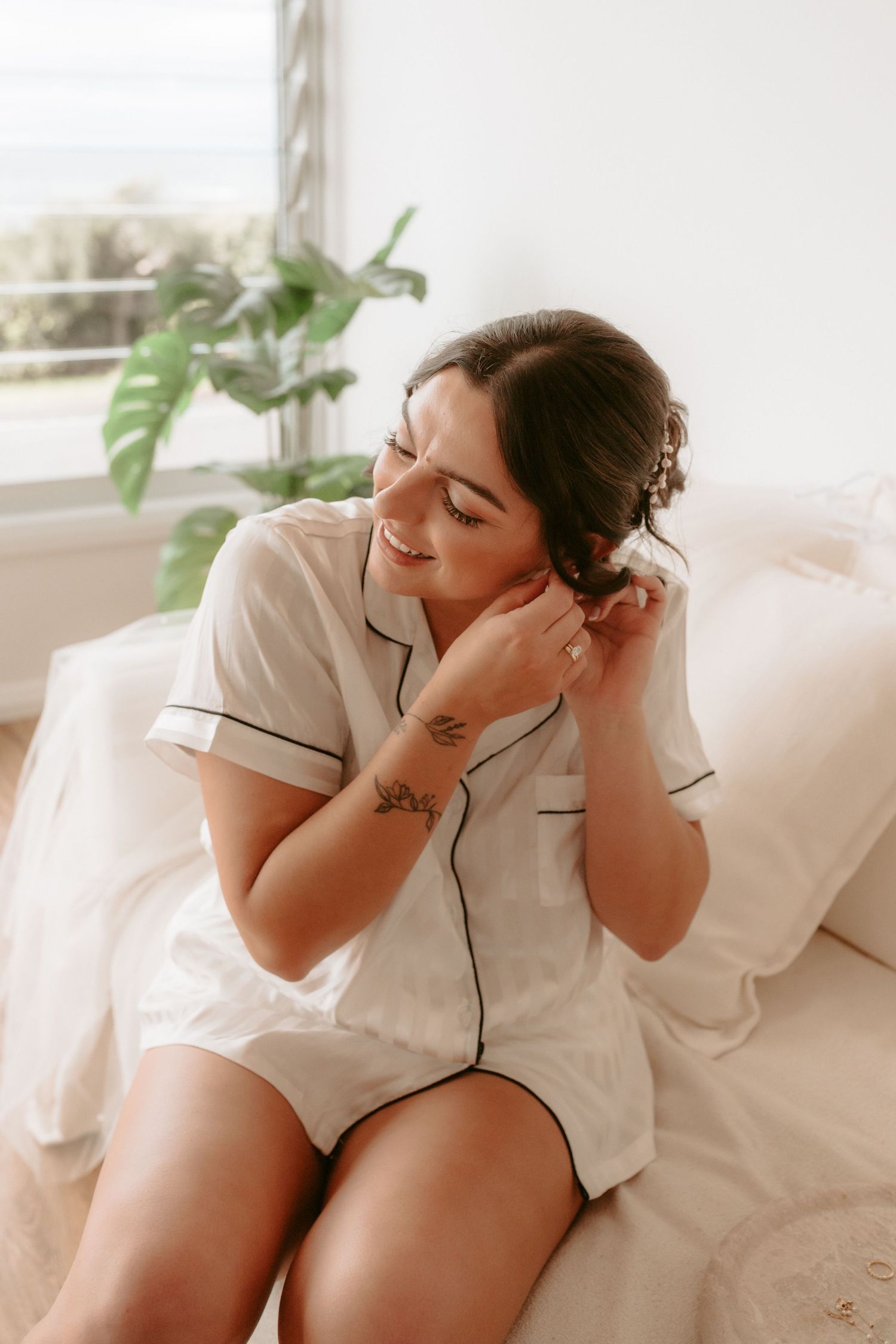 Woman in white sleepwear lounging on a light-colored couch.