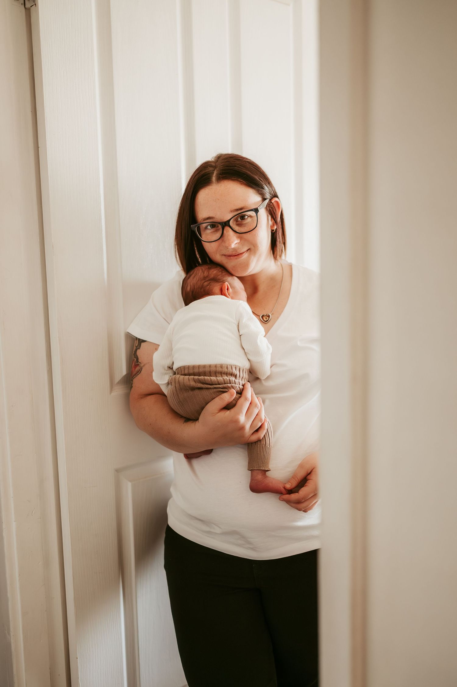 Indoor portrait with soft lighting showing tender moments with a newborn.