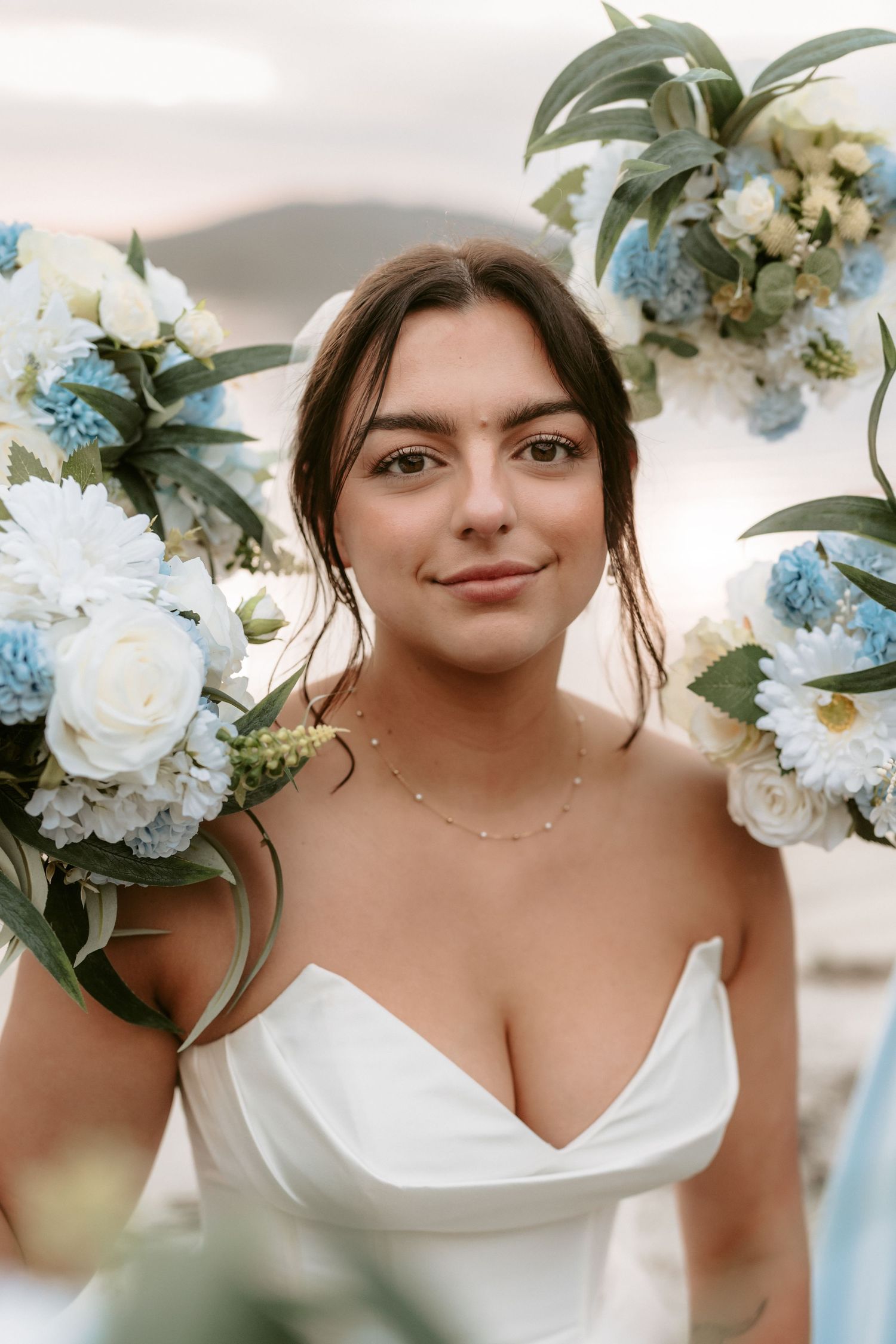 Wedding portrait with blue and white floral arrangements creating romantic frame.
