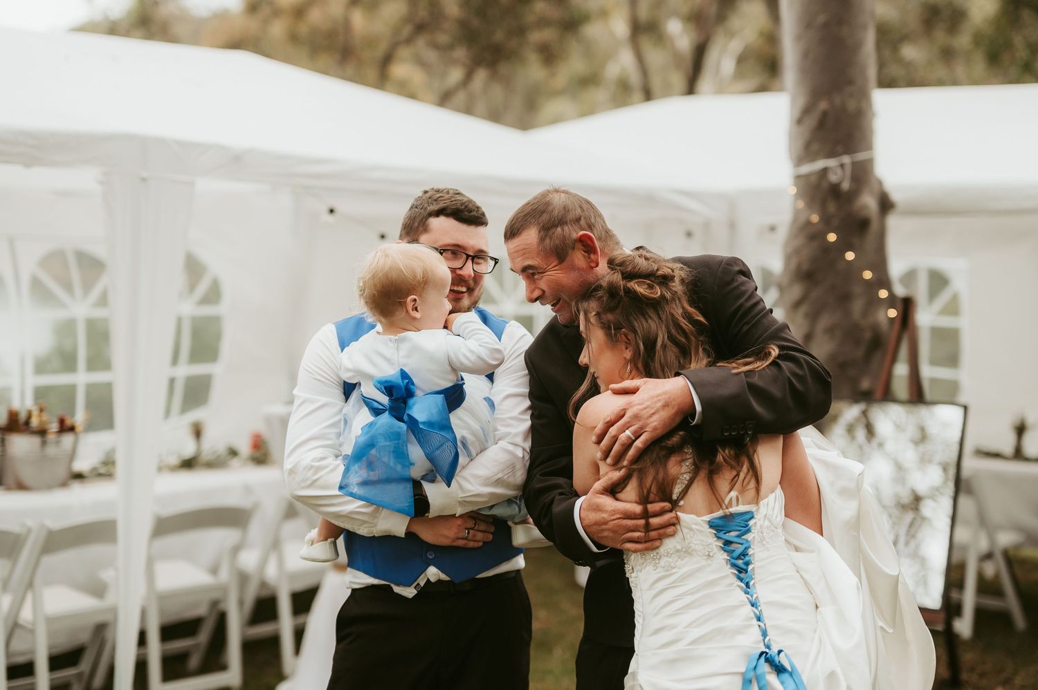 Wedding reception scene with white tents and dancing guests.