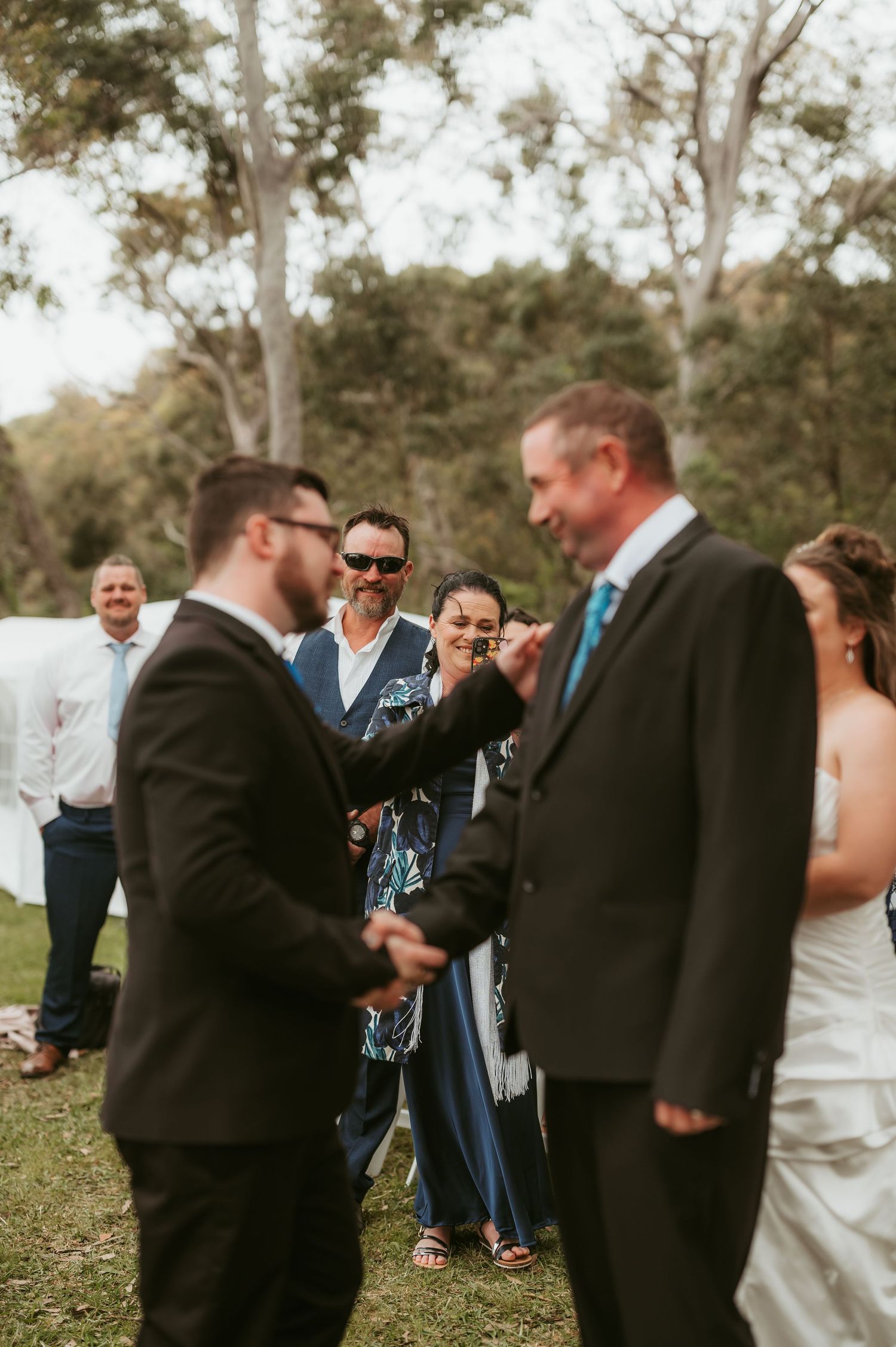Wedding ceremony guests gathered outdoors for celebration.