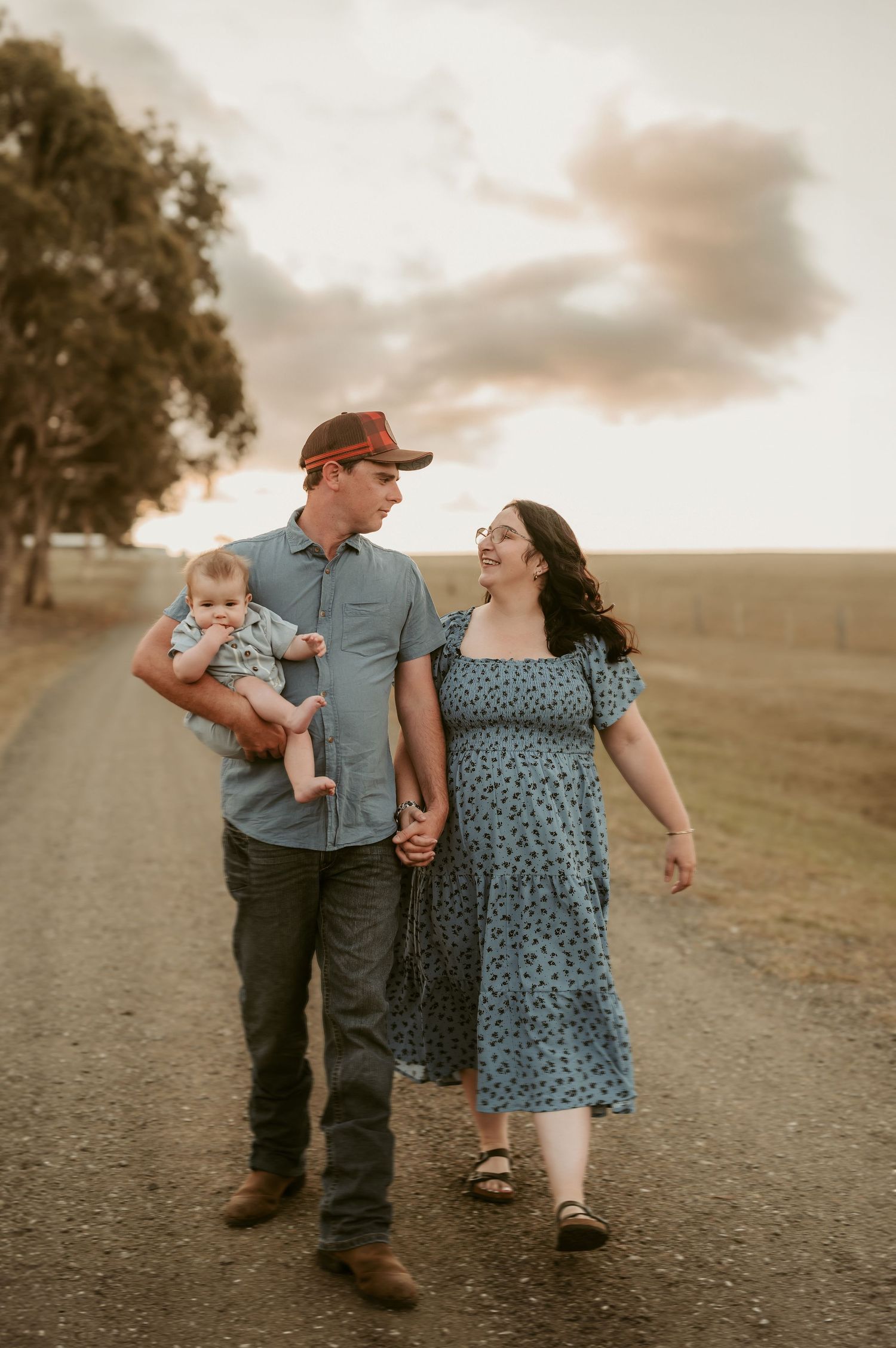 A family walking together on a dirt path during golden hour.