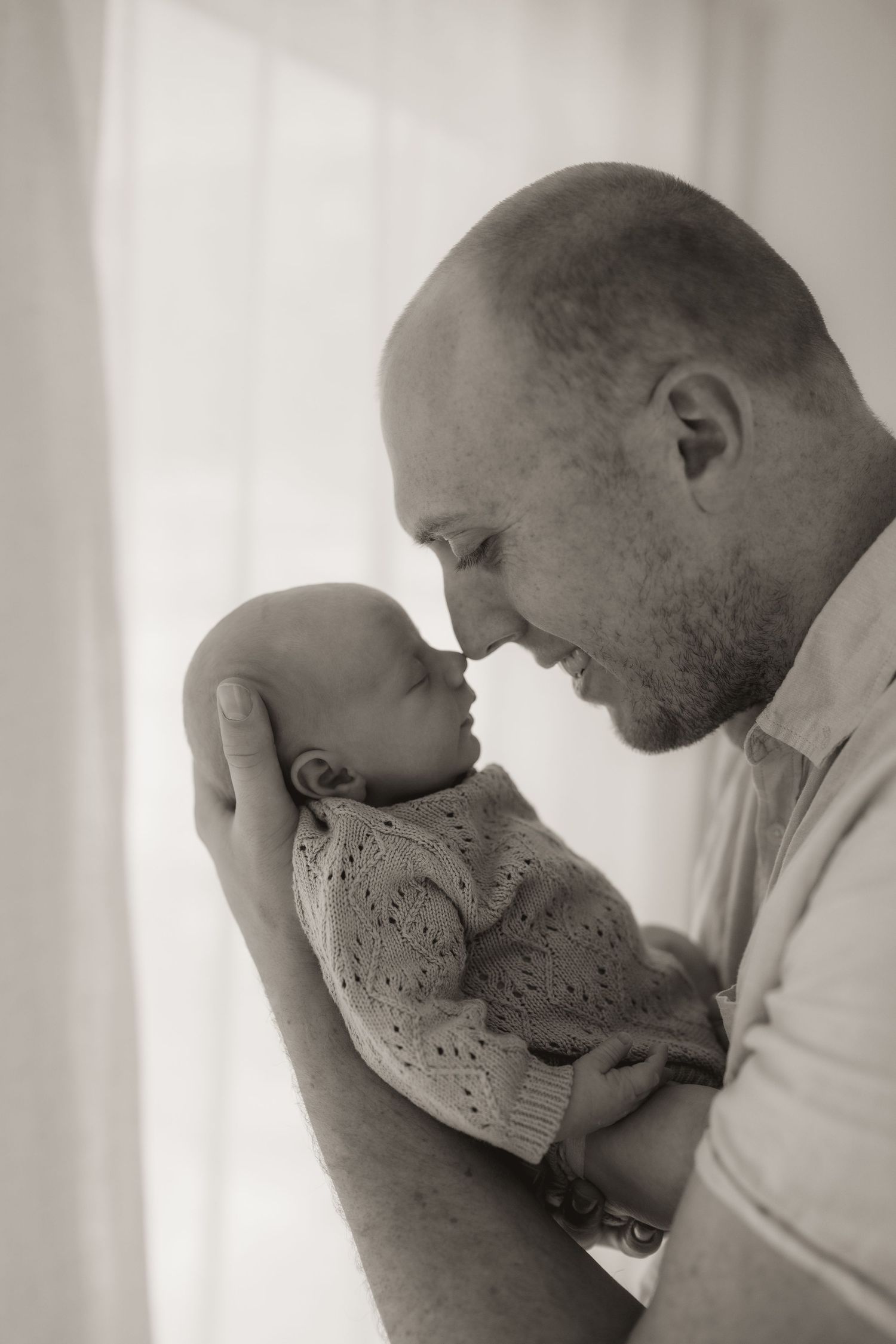 Black and white portrait of tender family moment with newborn.
