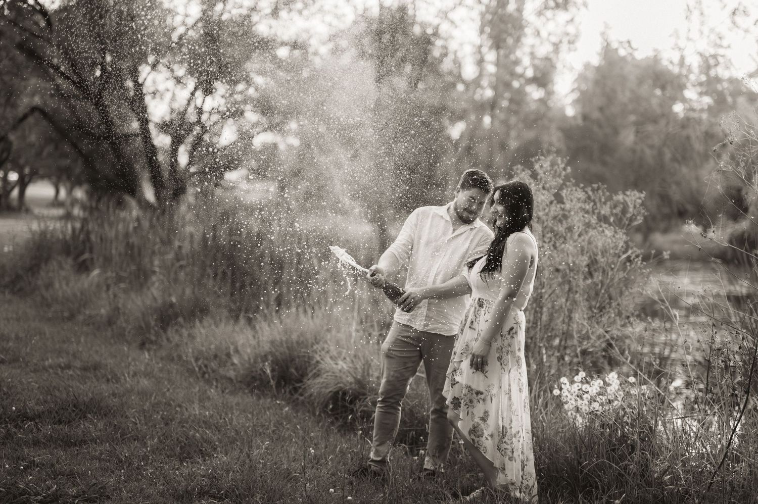 A romantic proposal scene captured in black and white on a nature path.