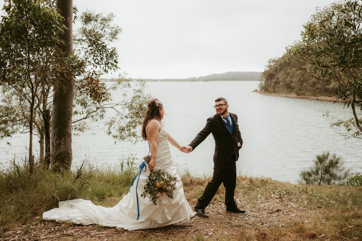 Wedding couple poses for artistic photos in a natural outdoor setting.