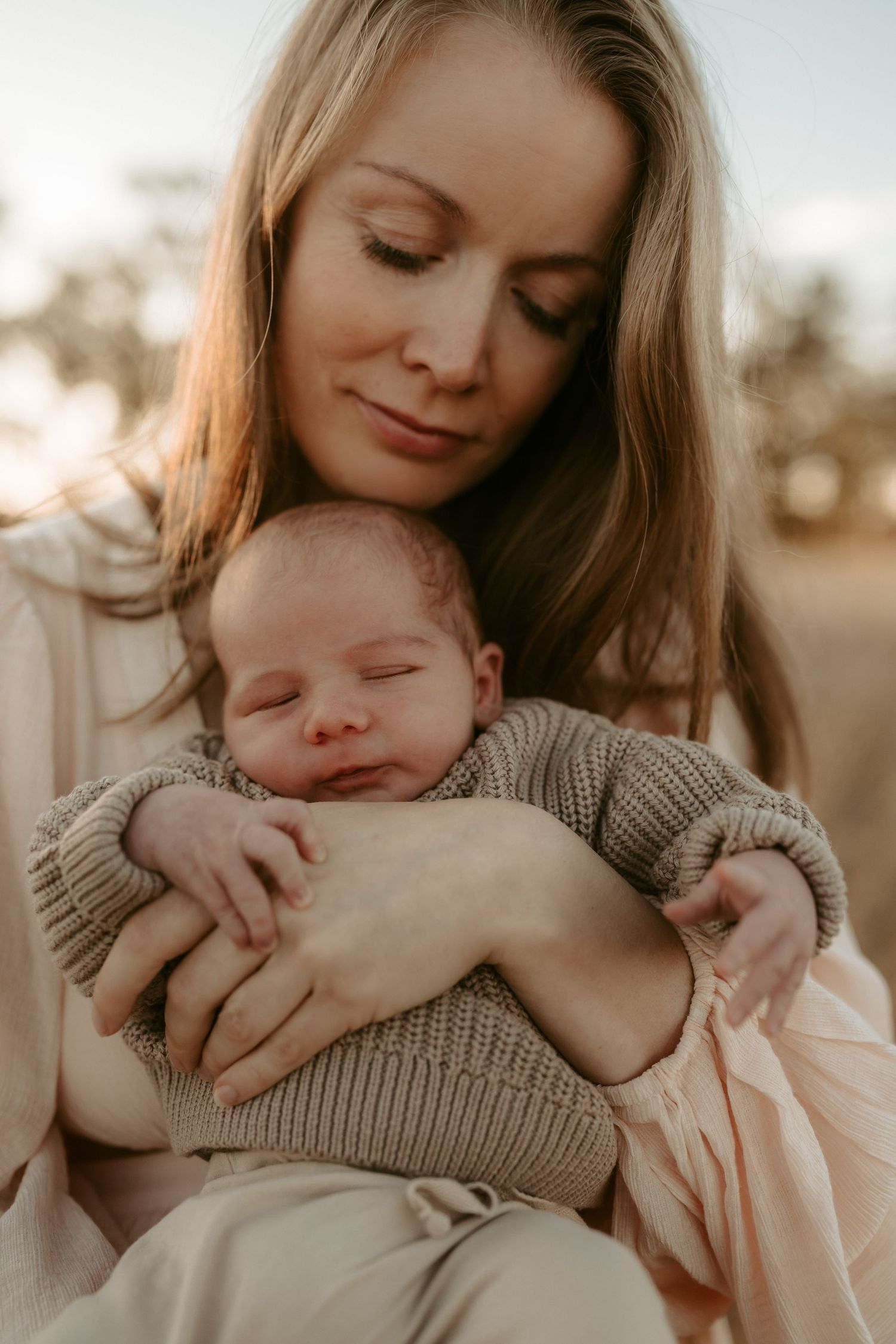 Tender moments between parent and newborn baby in warm natural lighting.