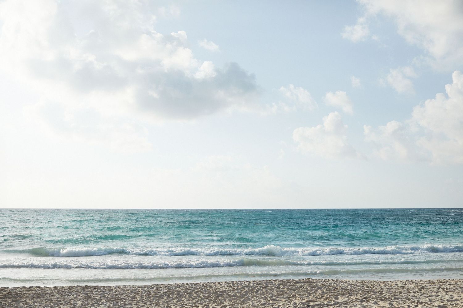 Photo of the ocean, sand and sky.