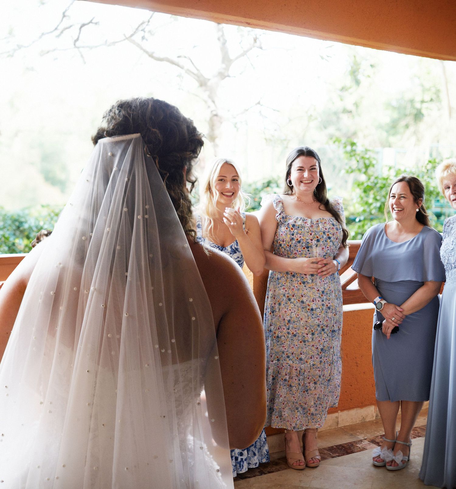 Bridesmaids and female wedding participants seeing the bride in her wedding dress.