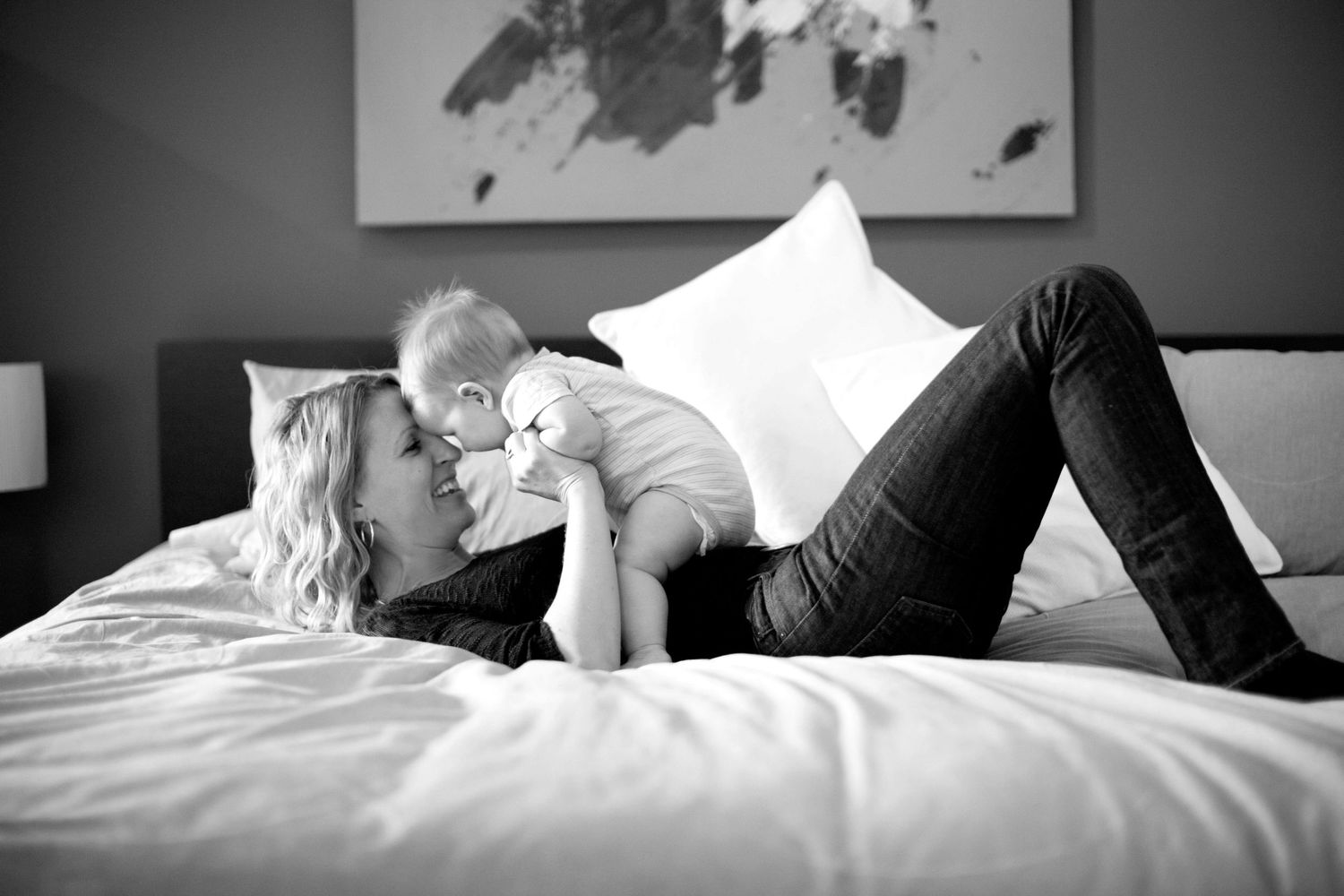 Mother and son playing on bed.