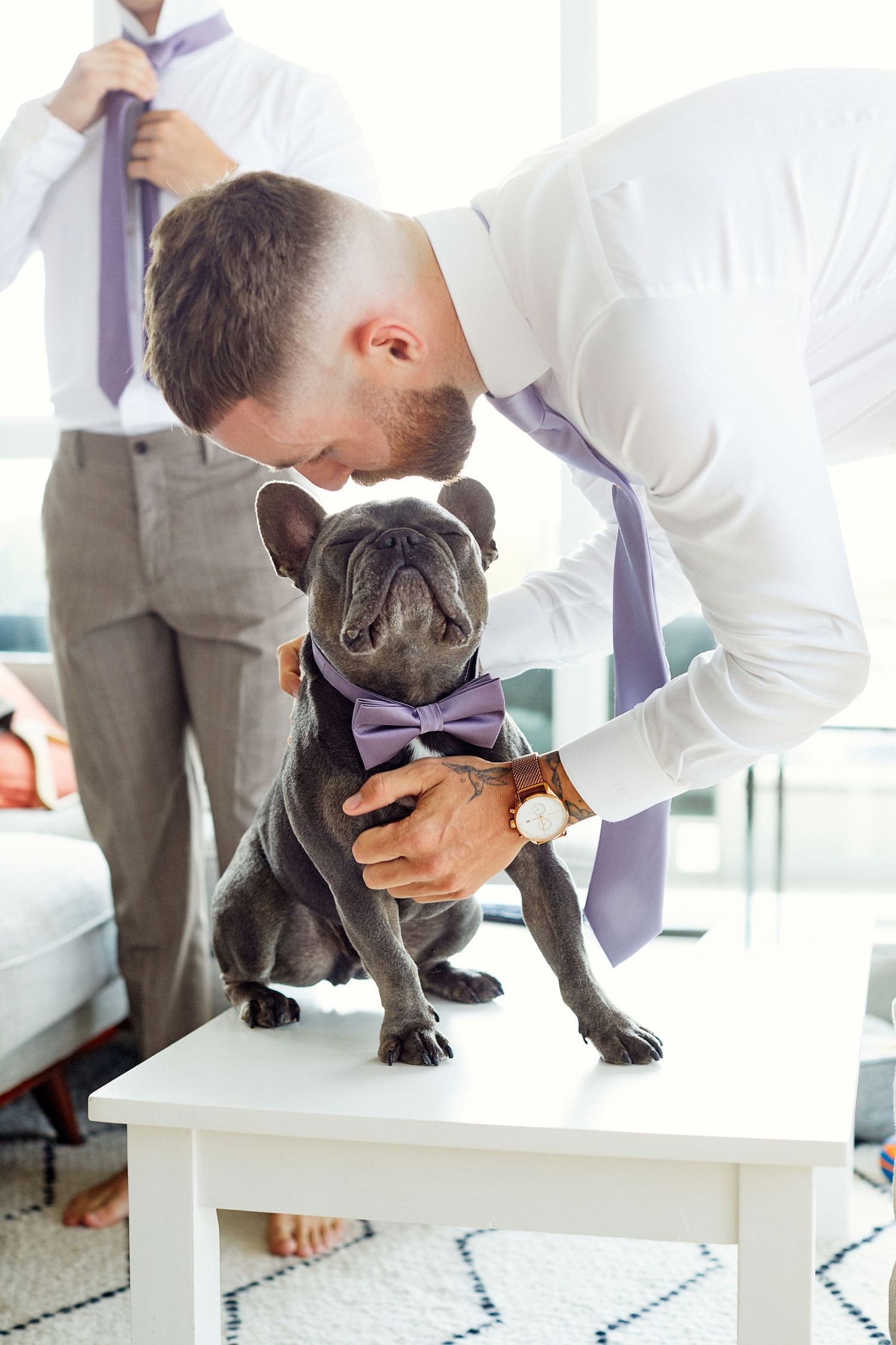 Groom kissing his dog.