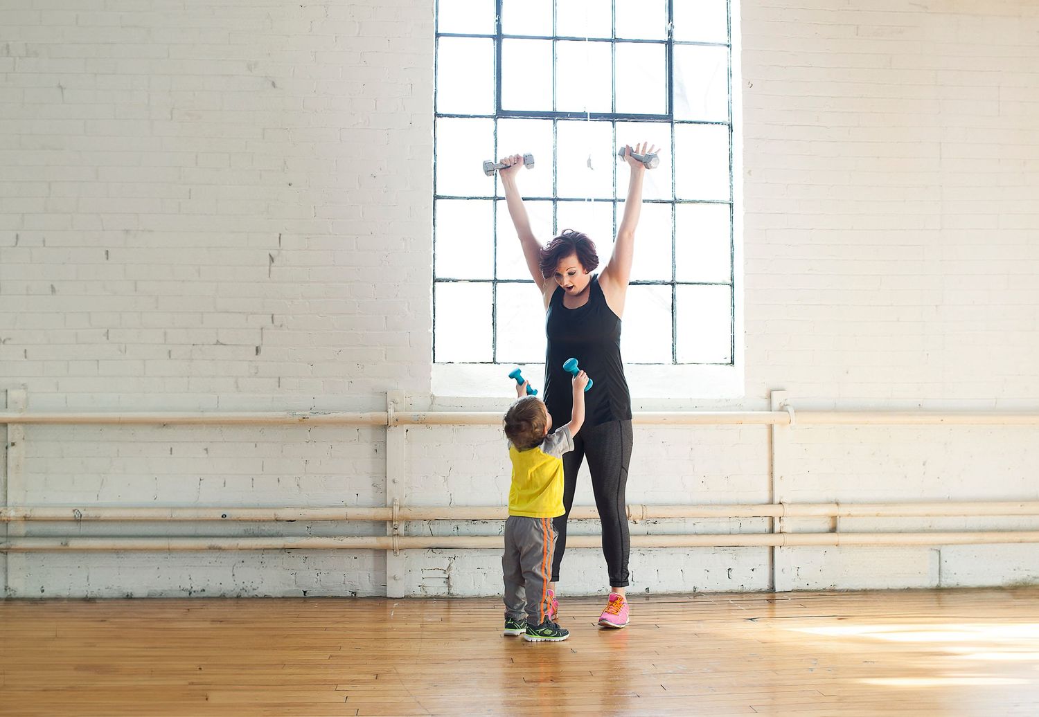 Photo of a mother and child lifting weights together.
