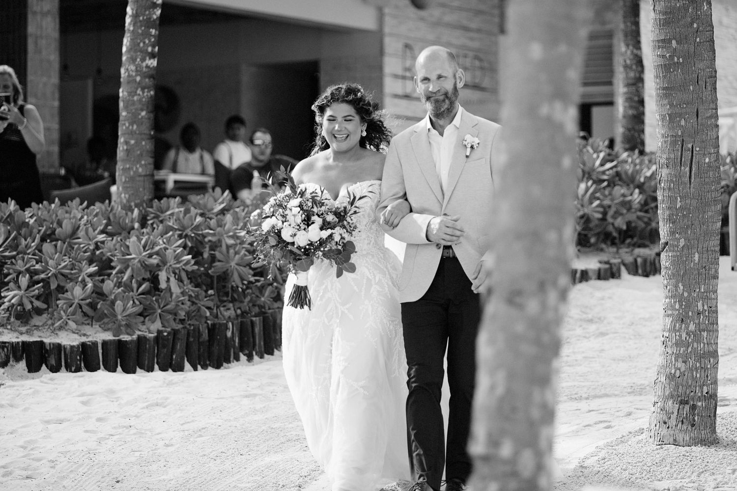 Bride and father of the bride walking down the aisle on the beach.