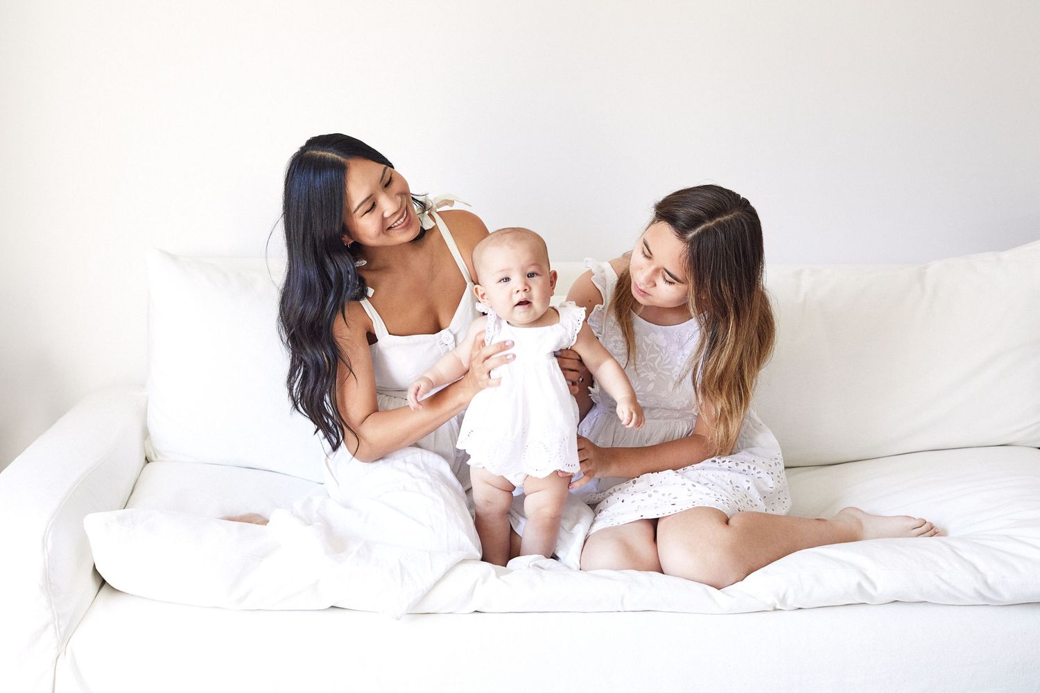 Family all dressed in white on white couch.
