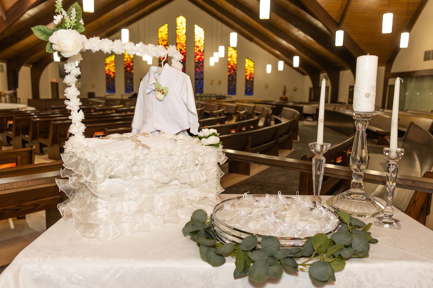 A traditional white wedding cake with multiple tiers decorated with delicate floral details and greenery.