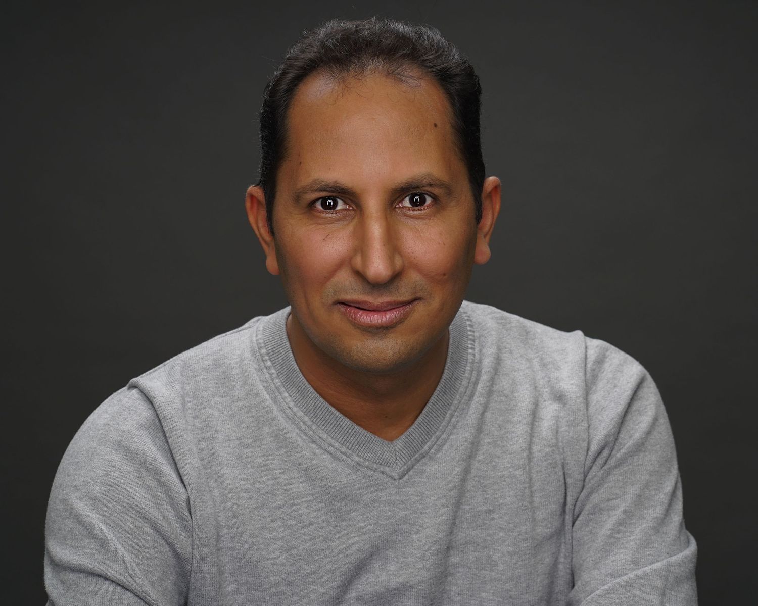 Professional headshots of a person in a grey shirt against dark background.