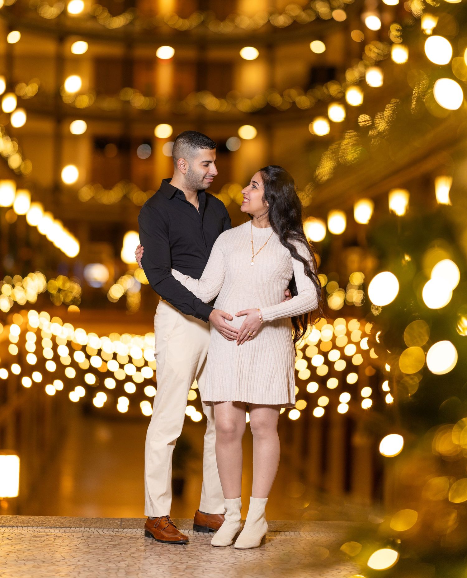 Romantic couple dancing under glowing string lights creating a magical evening atmosphere.