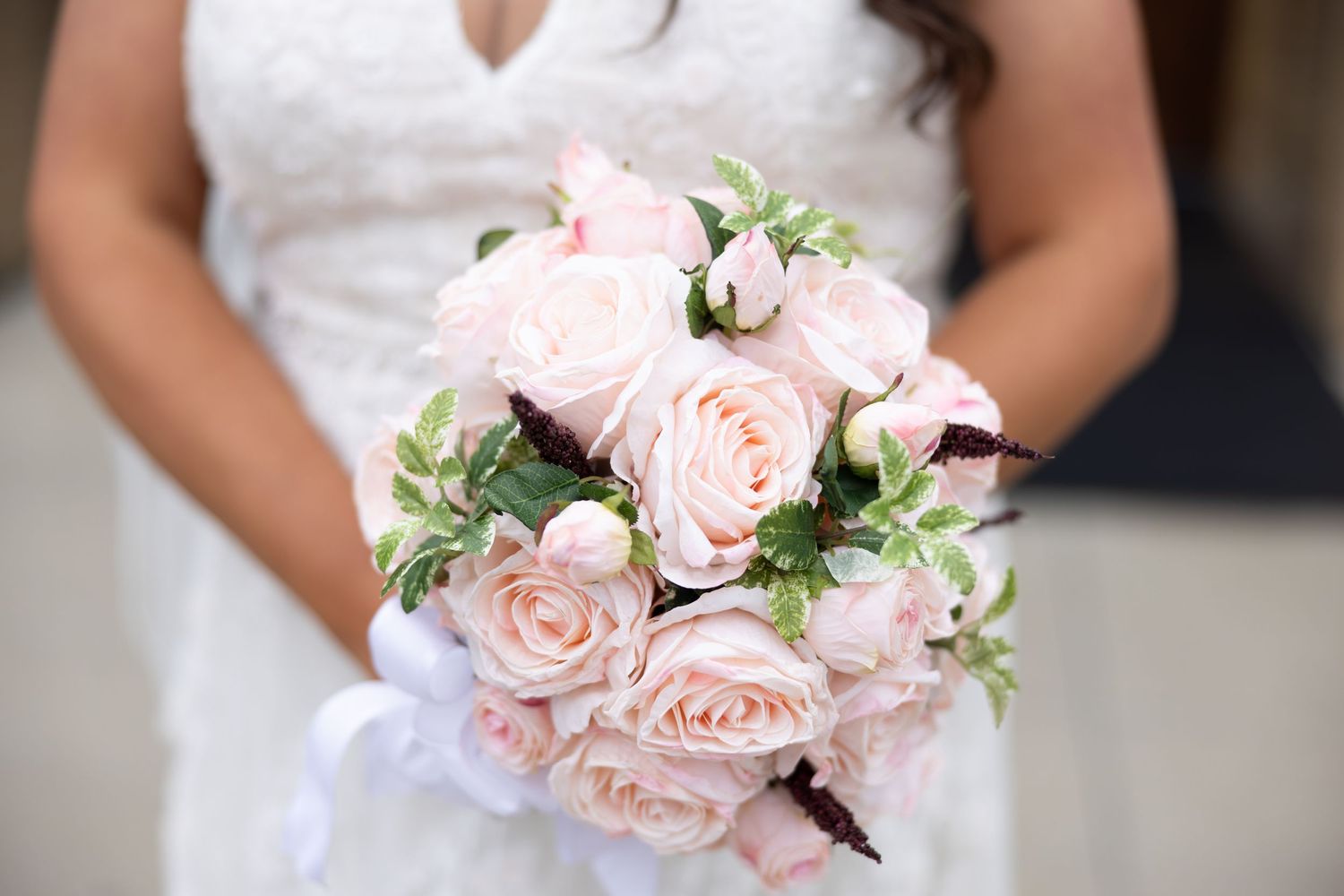 A collection of pink rose wedding bouquets held by bridesmaids in soft blush tones.