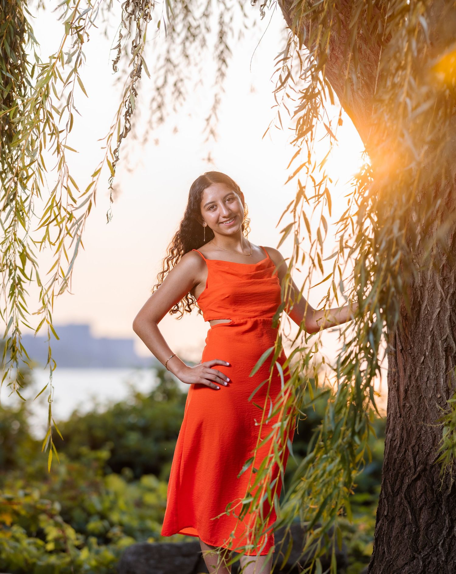 Series of photos featuring a bright orange dress against willow trees at sunset.