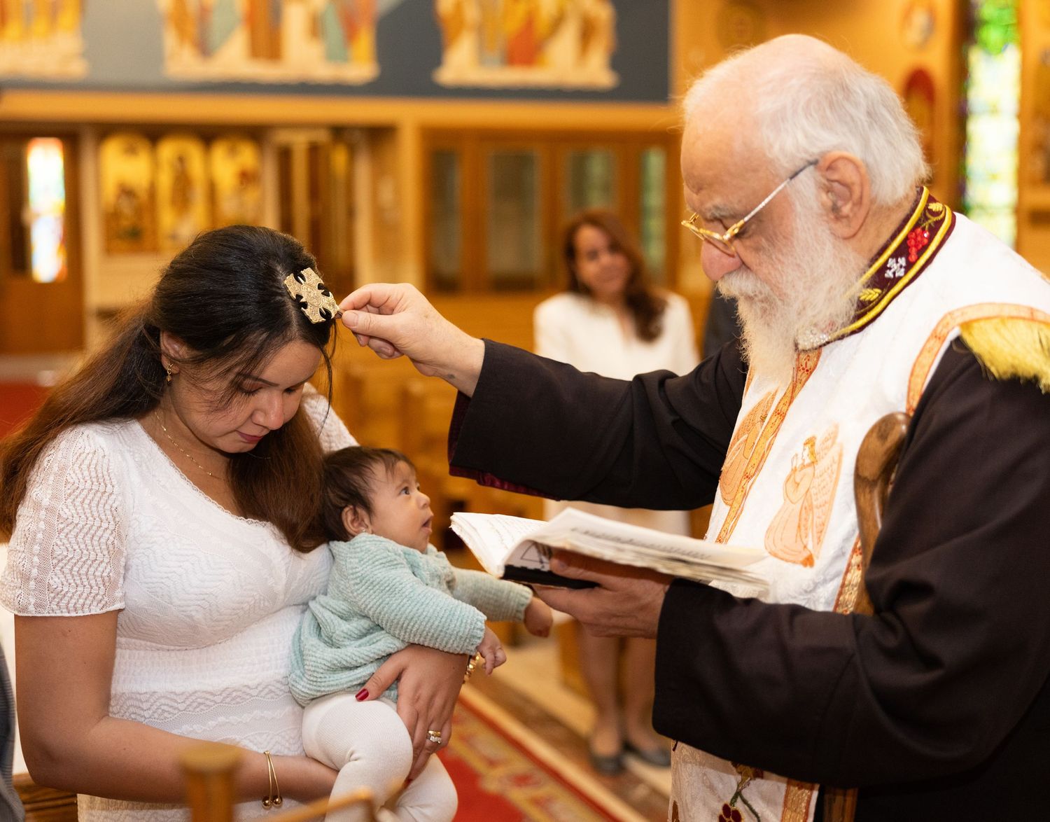 A couple exchanges rings during a traditional church wedding ceremony at the altar with warm lighting.