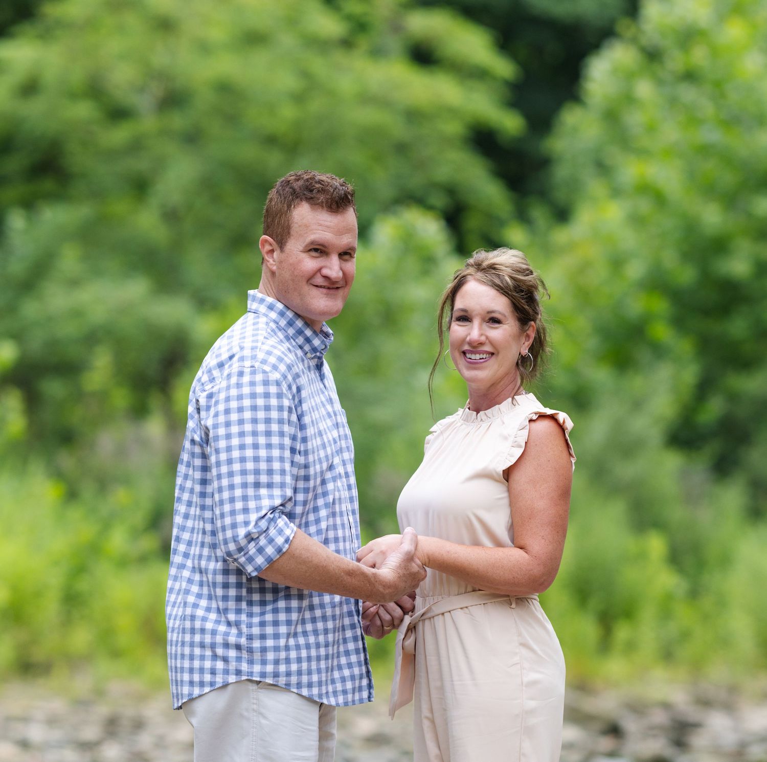 Couple dancing and smiling together outdoors in casual summer attire.