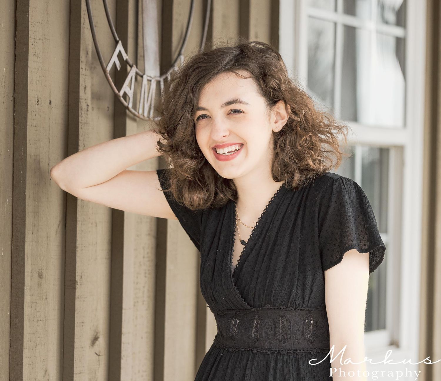 Fashion portraits in a black dress against an architectural backdrop.