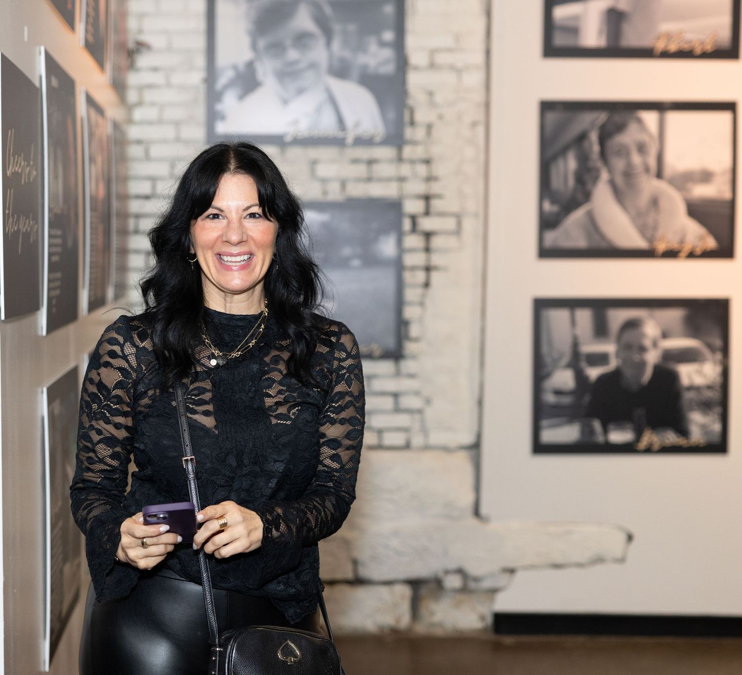 A gallery space with black and white photographs displayed on exposed brick walls.