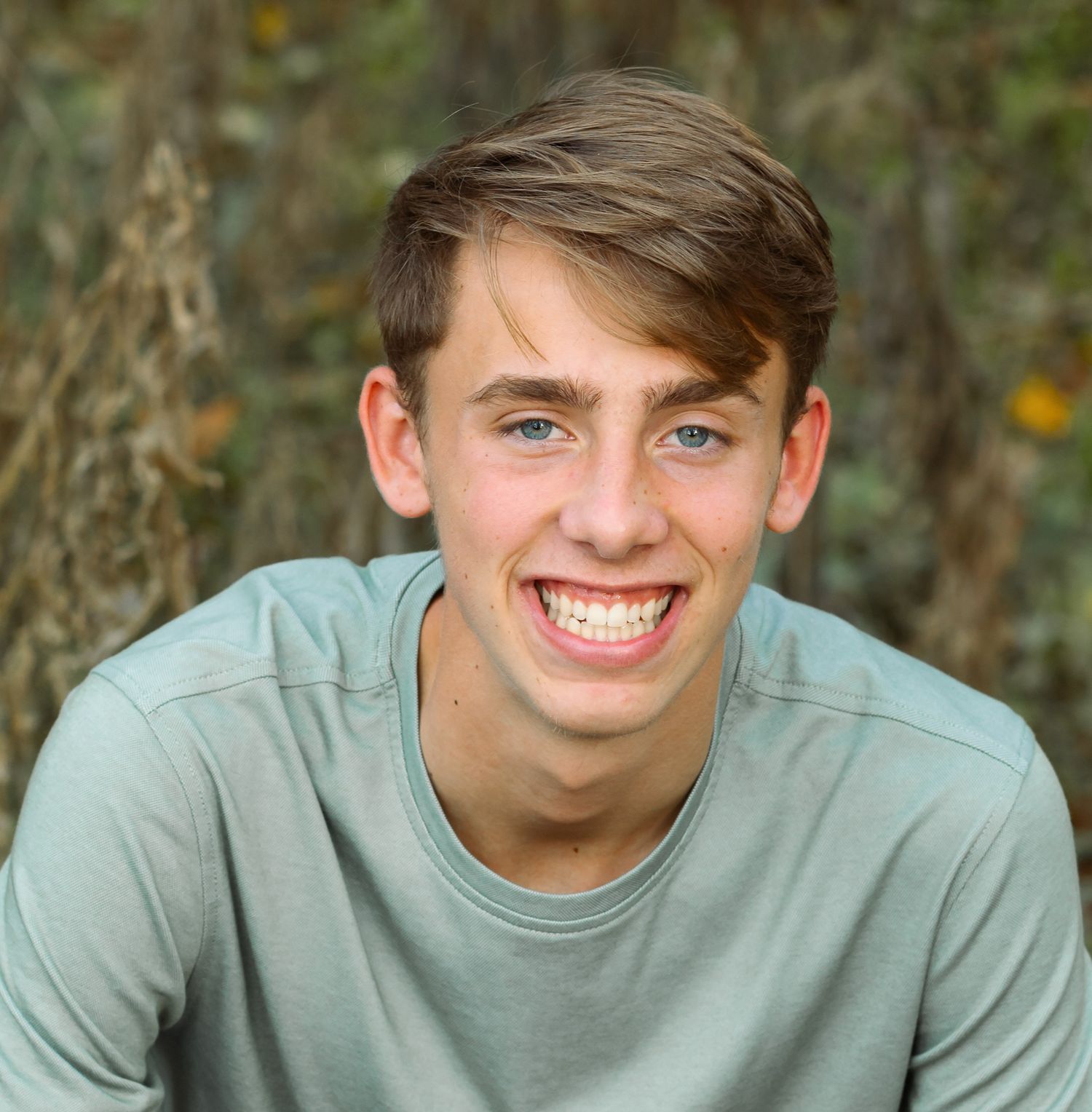 A series of four headshot portraits showing someone in a light gray t-shirt against a blurred outdoor background.