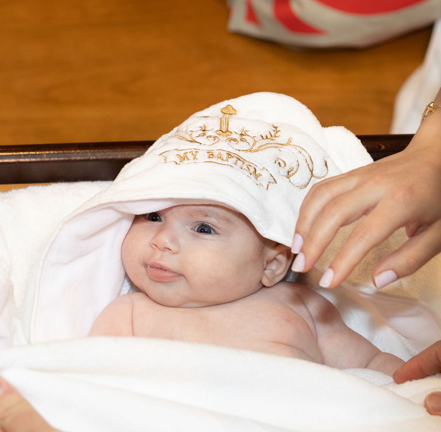 A baby lying on a changing table receives gentle care during a diaper change.
