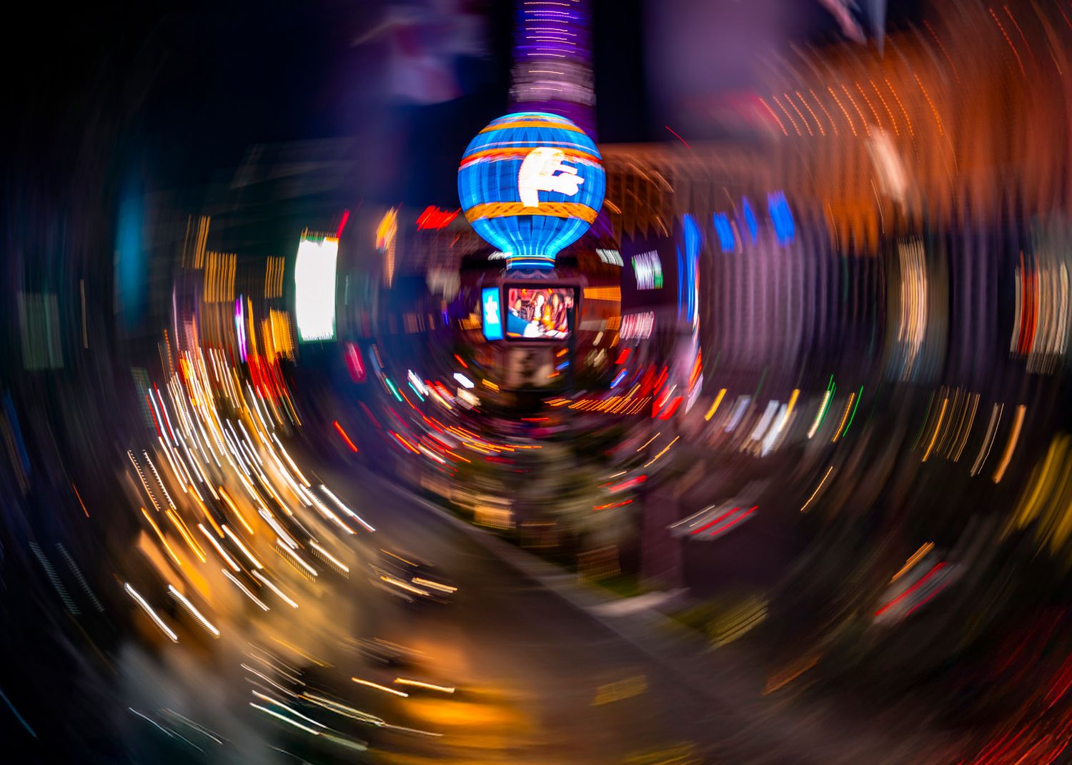 Neon lights swirling around a balloon sign on the Las Vegas Strip