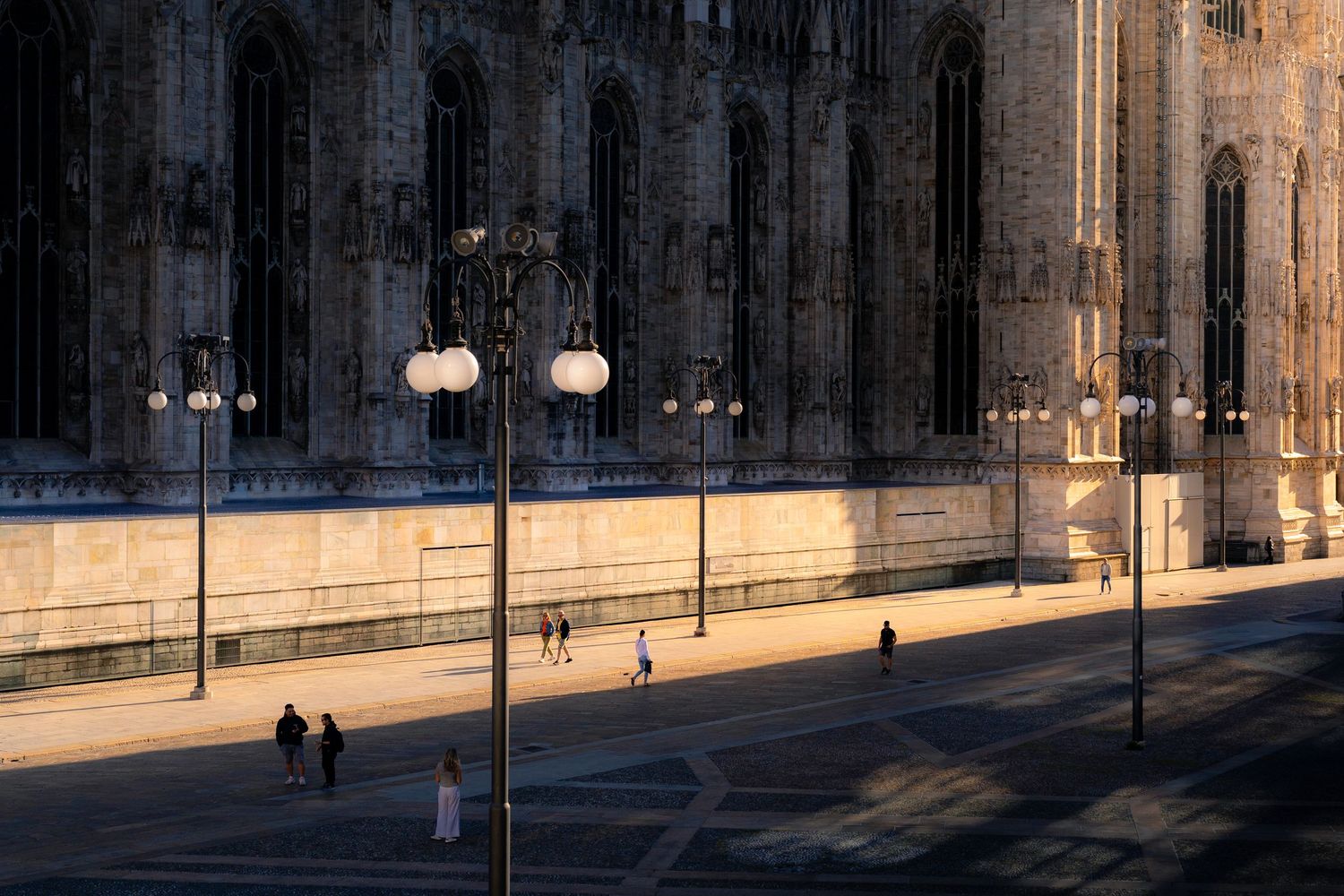 Architectural details of Milan’s Duomo highlighted by low sunlight and long shadows.