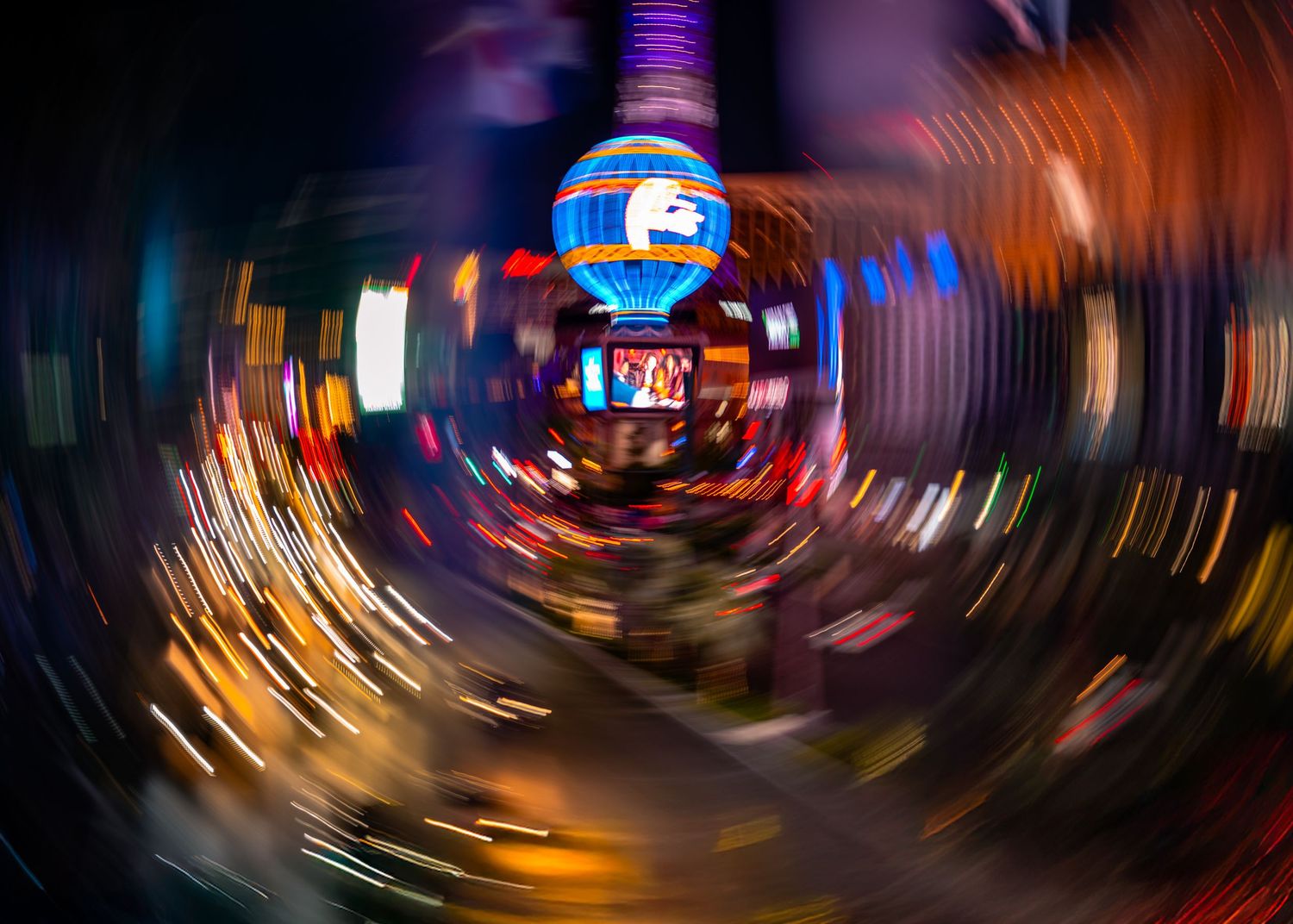 Long-exposure motion blur of neon lights spinning along the Las Vegas Strip at night.