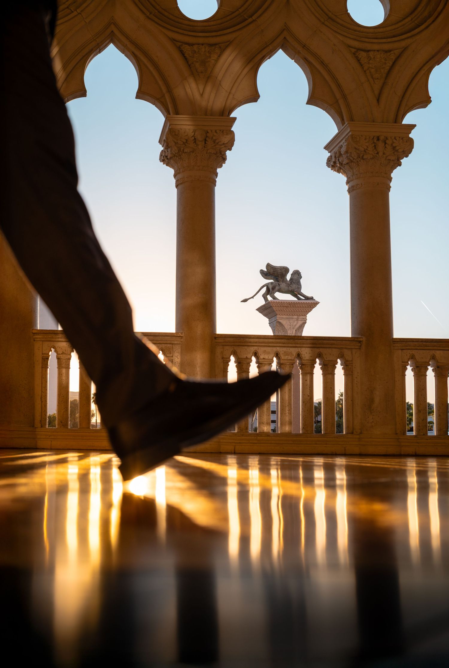 A person’s foot stepping through warm sunlight on a polished floor in Las Vegas.