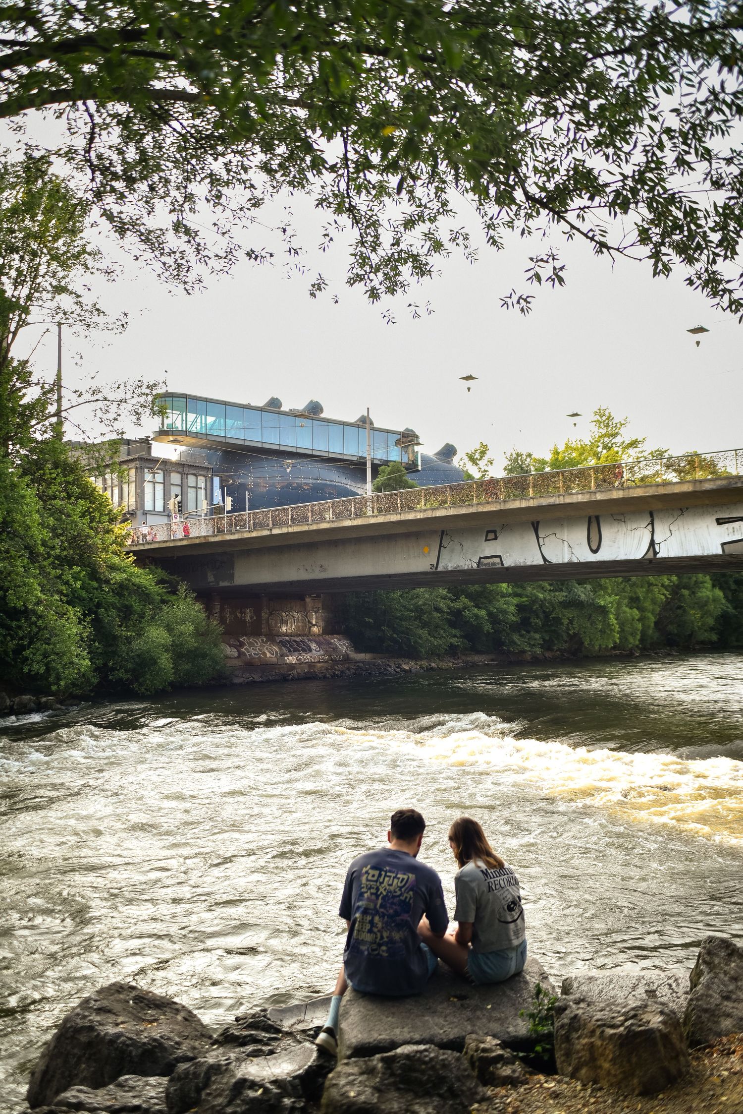 Two people sitting and watching the river, Graz