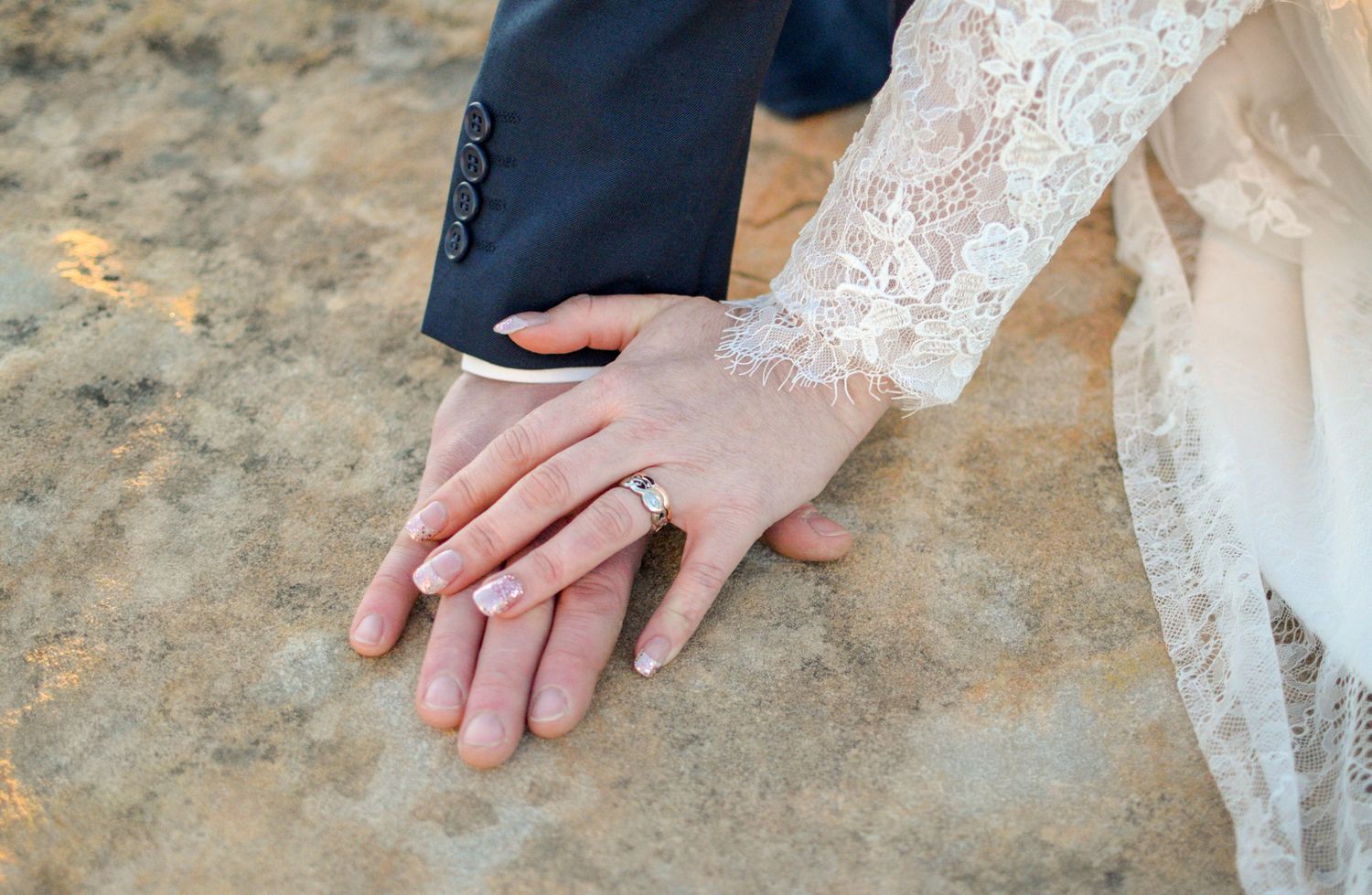 Close-up shots of hands with wedding rings resting on textured stone surfaces.