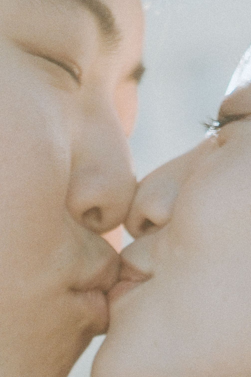Close-up of a couple sharing a tender kiss on their wedding day.