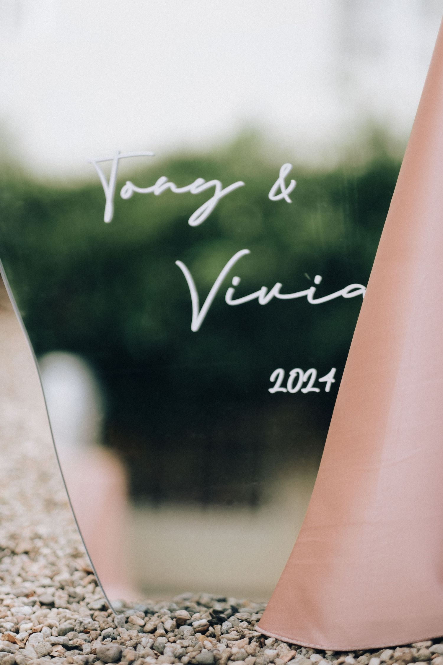 Acrylic wedding sign reading Tony and Vivian 2024 displayed outdoors.