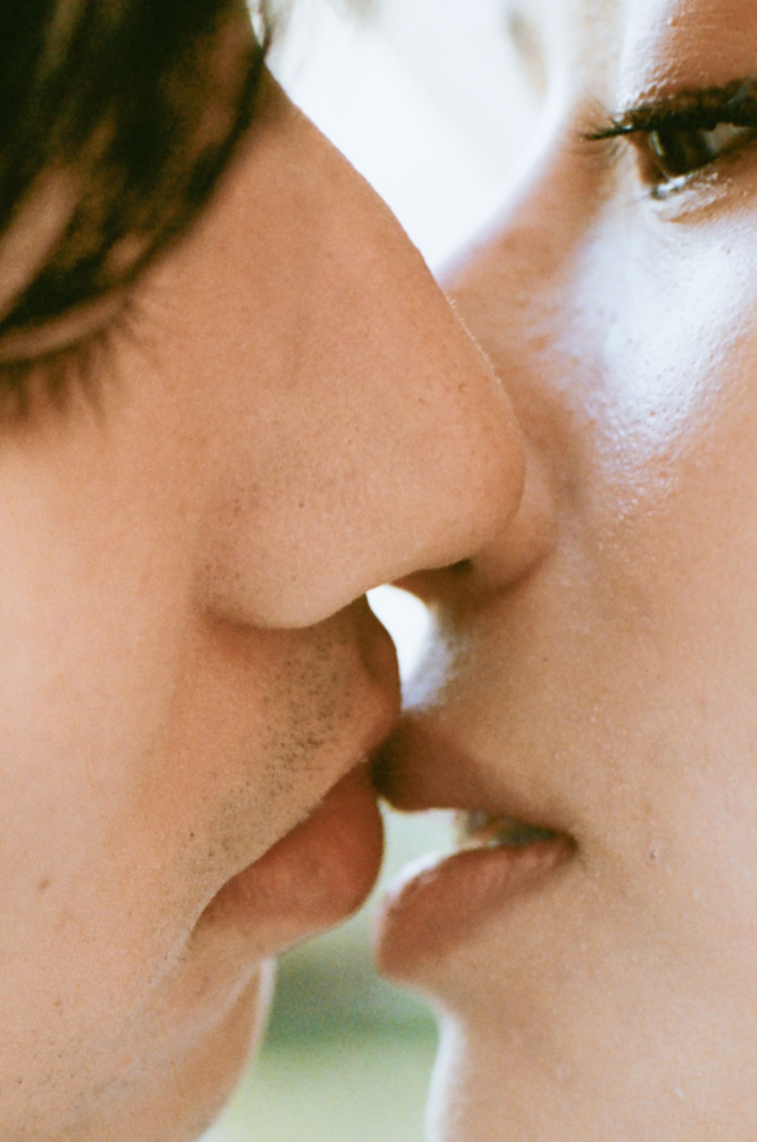 Intimate close-up of a couple sharing a kiss, capturing a tender romantic wedding moment.