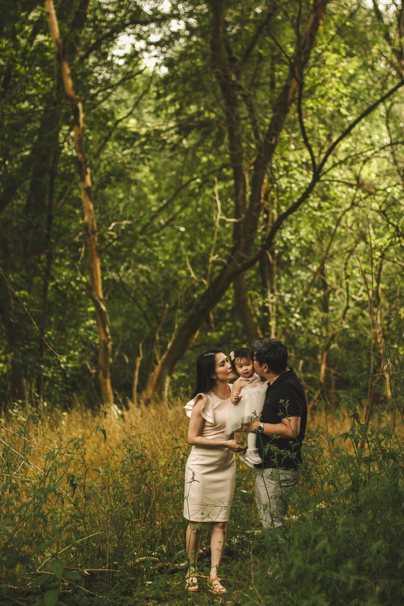 Family photography in Toronto of parents and their daughter, natural landscape of forest