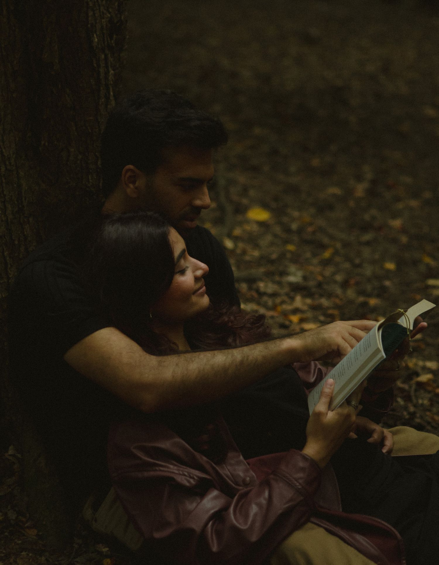 Cinematic documentary-style couples photography taken outdoors in Ontario, couple reading by a tree