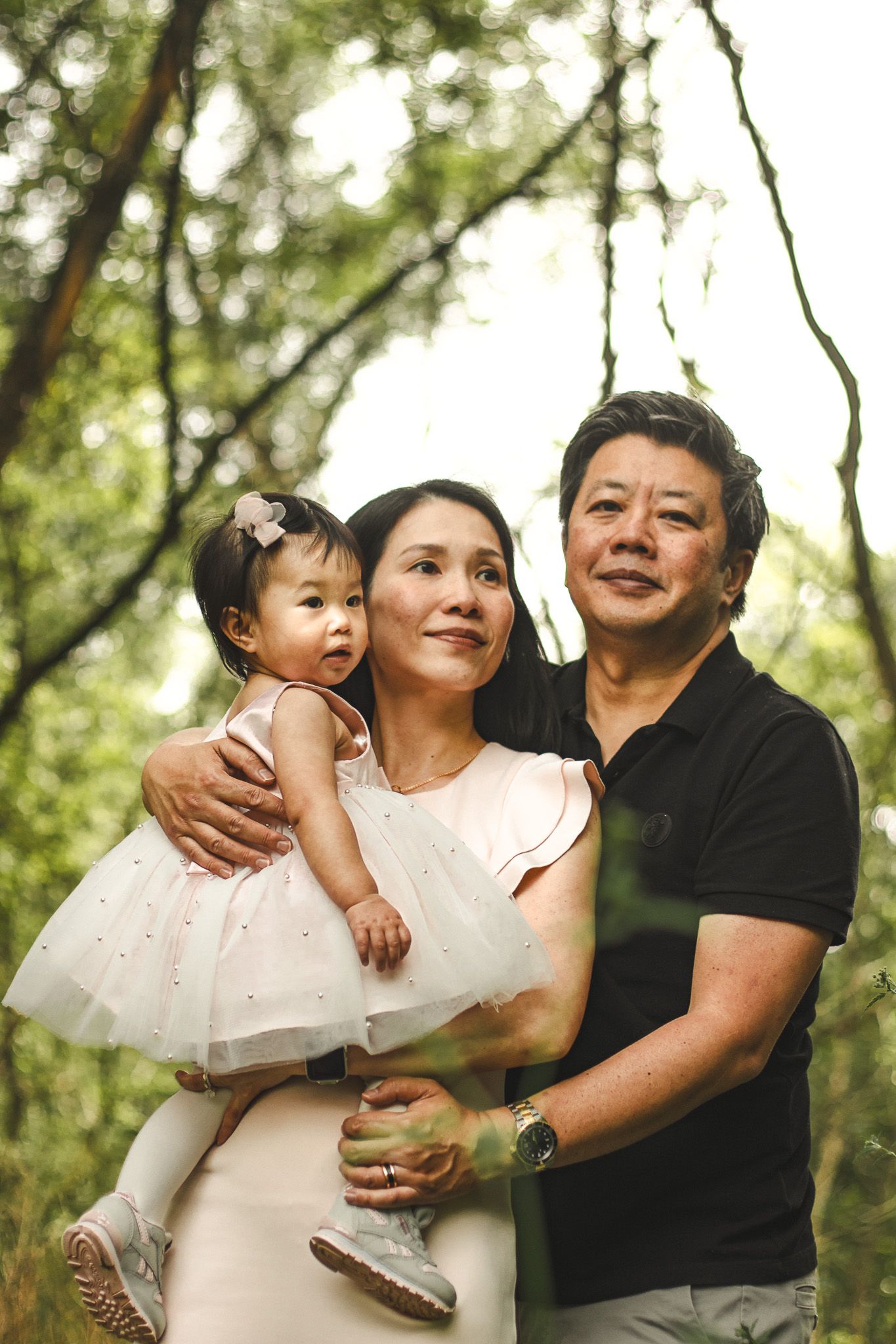 Family photography in Toronto of parents and their daughter, natural landscape of forest