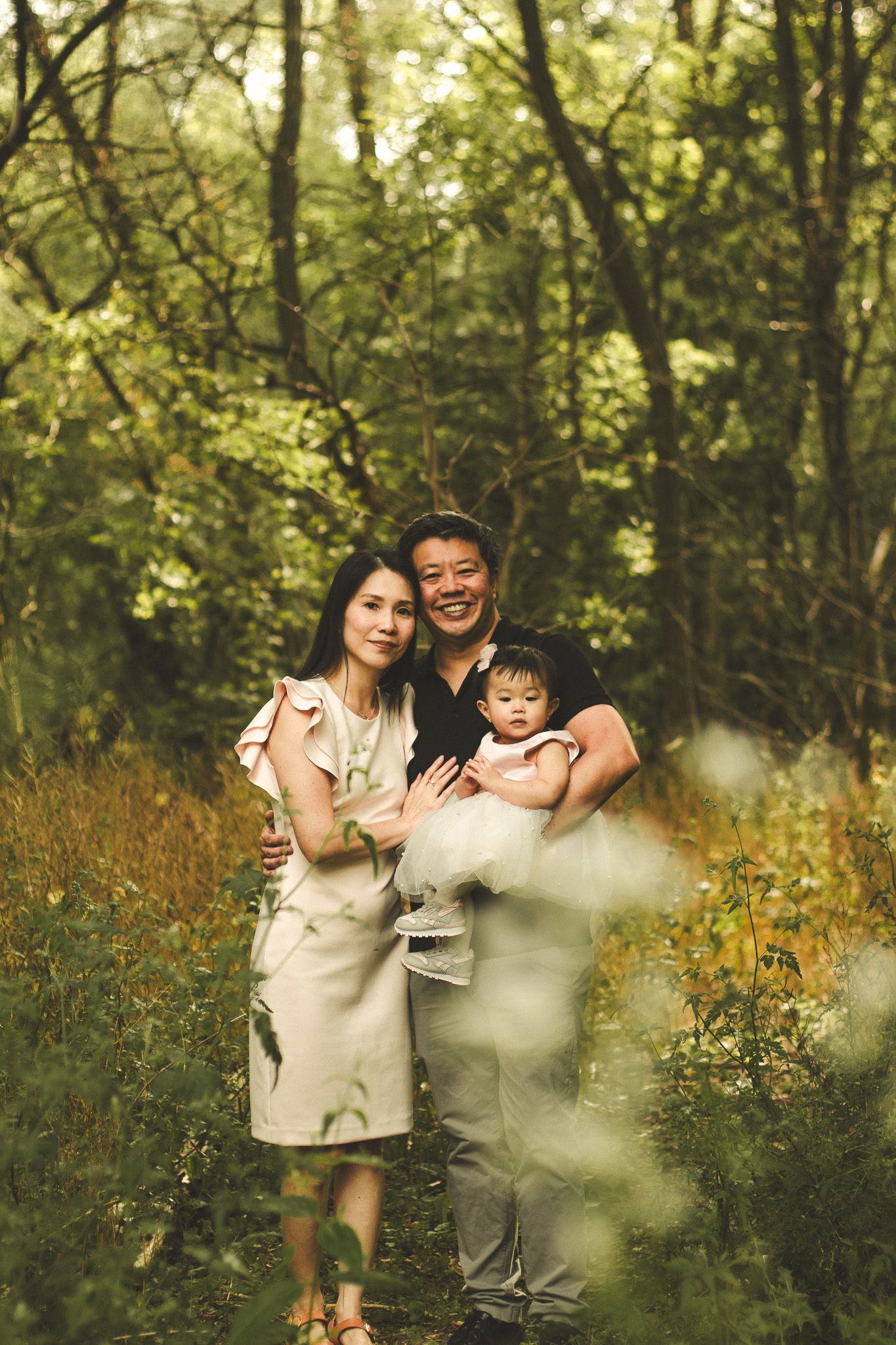 Family photography in Toronto of parents and their daughter, natural landscape of forest