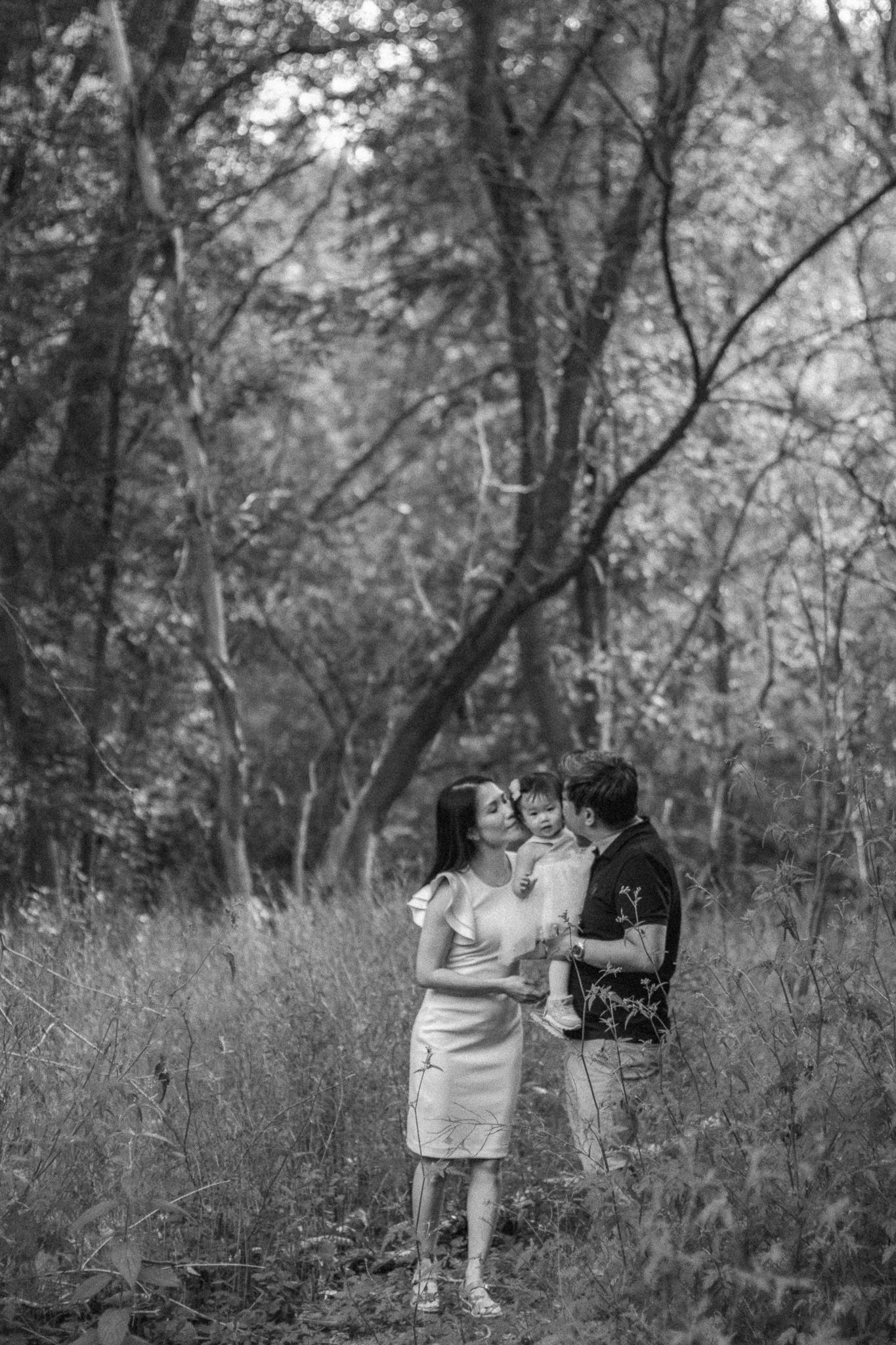 Family photography in Toronto of parents and their daughter, natural landscape of forest