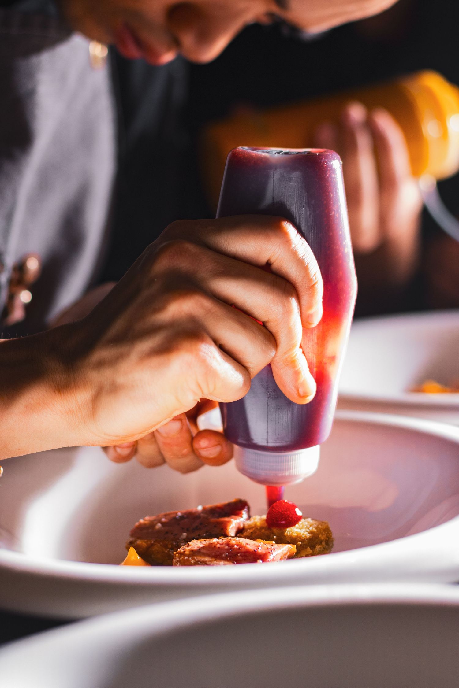 Food photography for tasting menu, clean style, chef putting finishing touches on dish (jam detailing)
