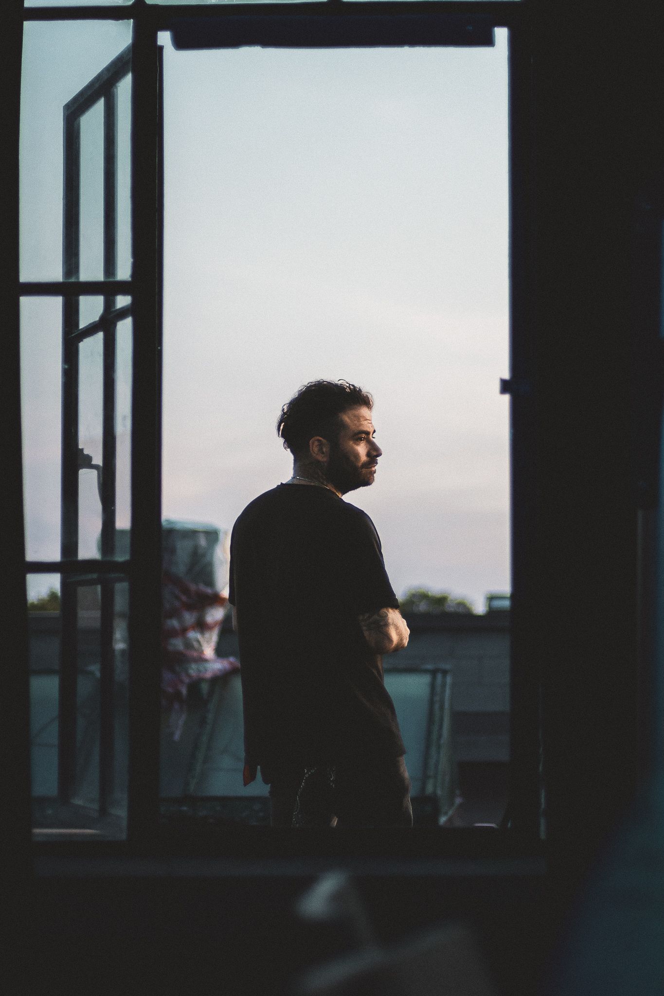 Candid musical event photography, man standing outside window on balcony