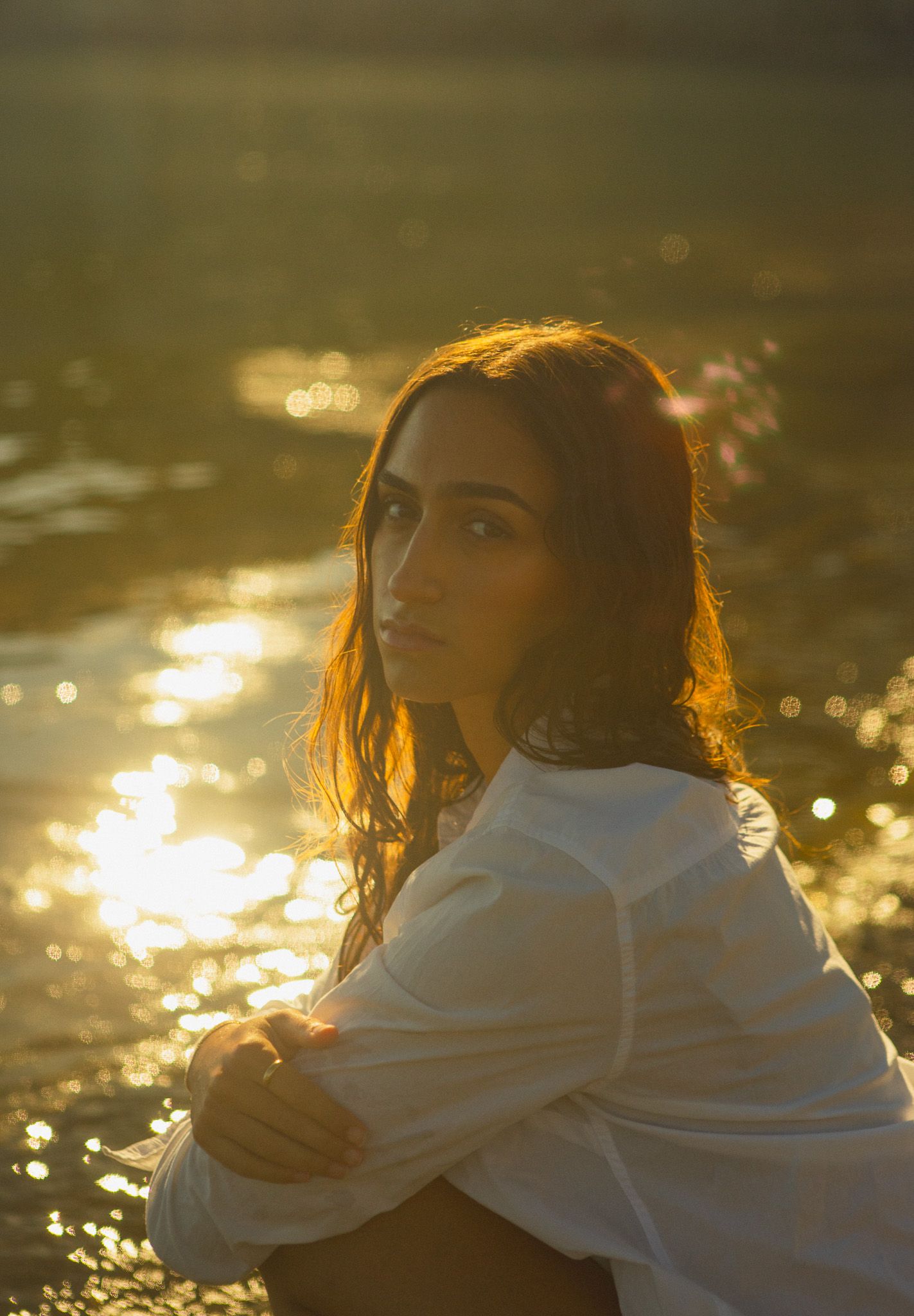 Portrait photography of girl sitting on beach by the water, Toronto golden hour